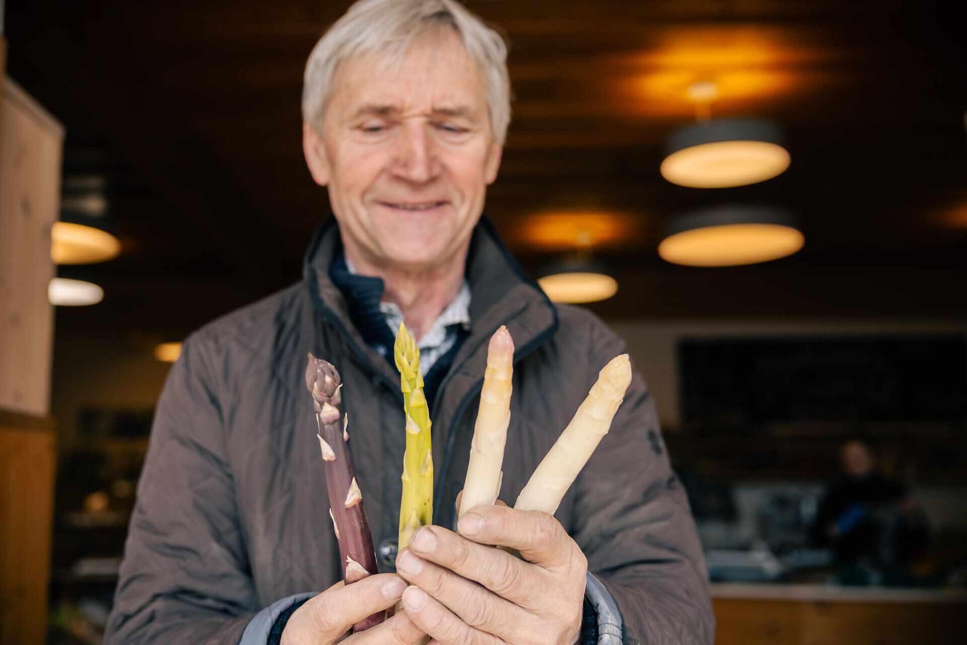 Spargelbauer Werner Magoschitz hält vier verschiedene Spargelsorten in den Händen. 