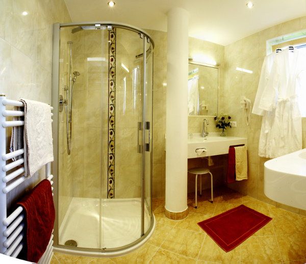 Modern fürdőszoba zuhanyzóval, mosdókagylóval és törölközőtartóval.