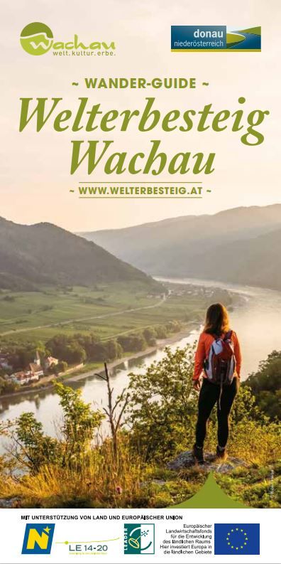 Eine Frau steht auf einem Berg am Welterbesteig Wachau und blickt Richtung Donau.