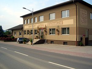 Zweistöckiges Gebäude mit der Aufschrift 'Gasthof Kögl'.