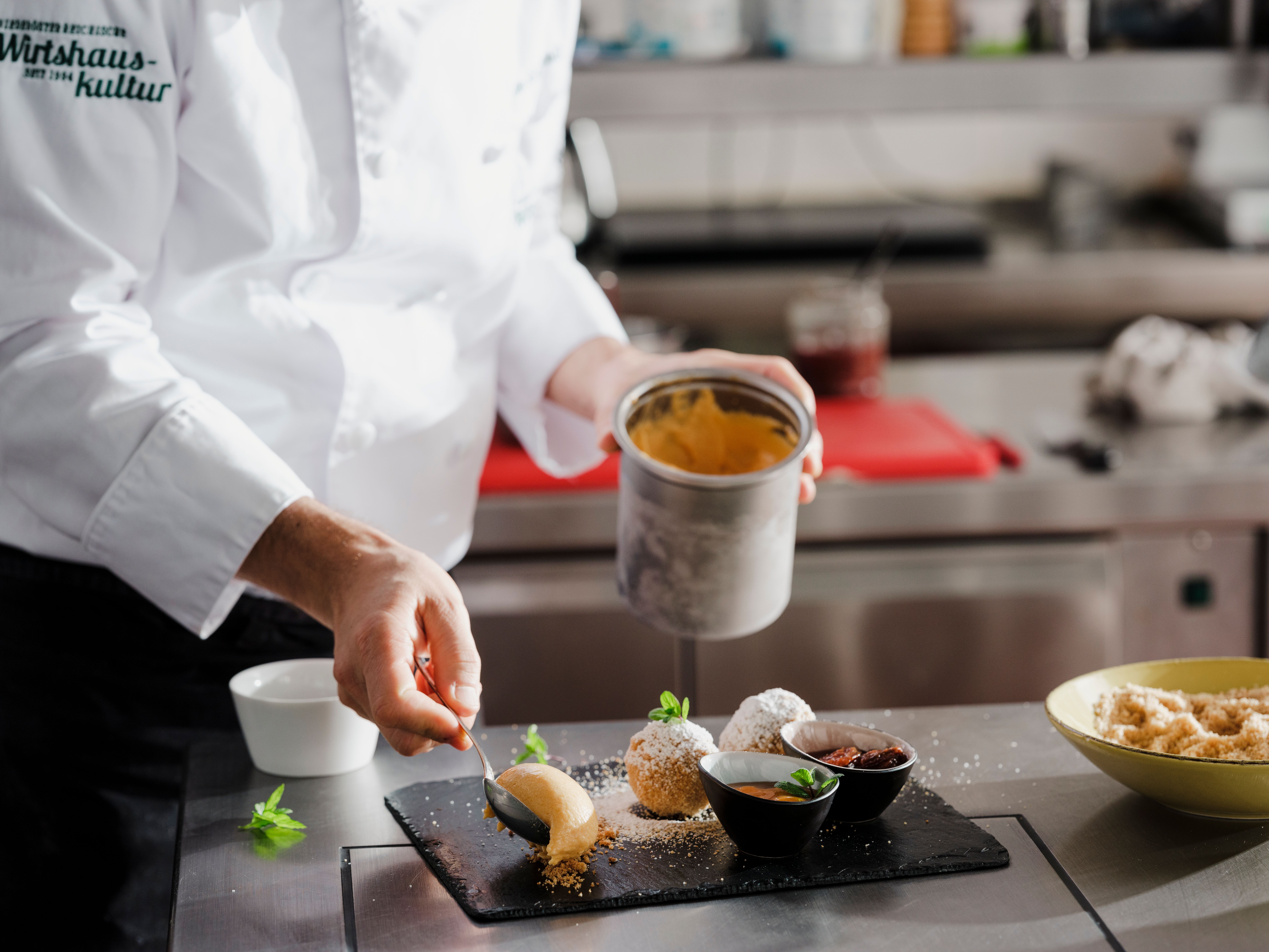 Chef Roman Siebenhandl kneels in the garden and harvests saffron with tweezers.
