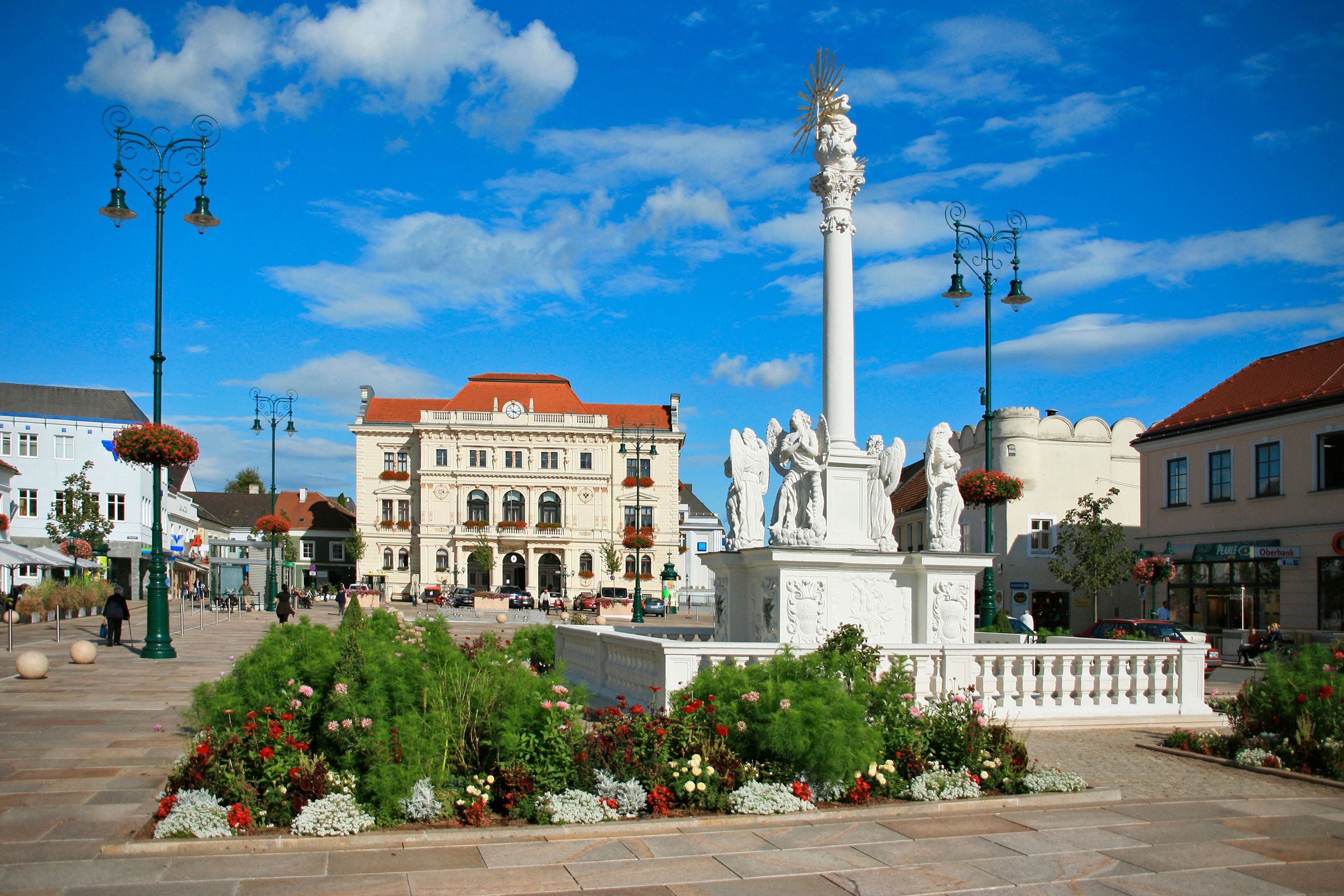 Main square in Tulln with baroque column and historic buildings.