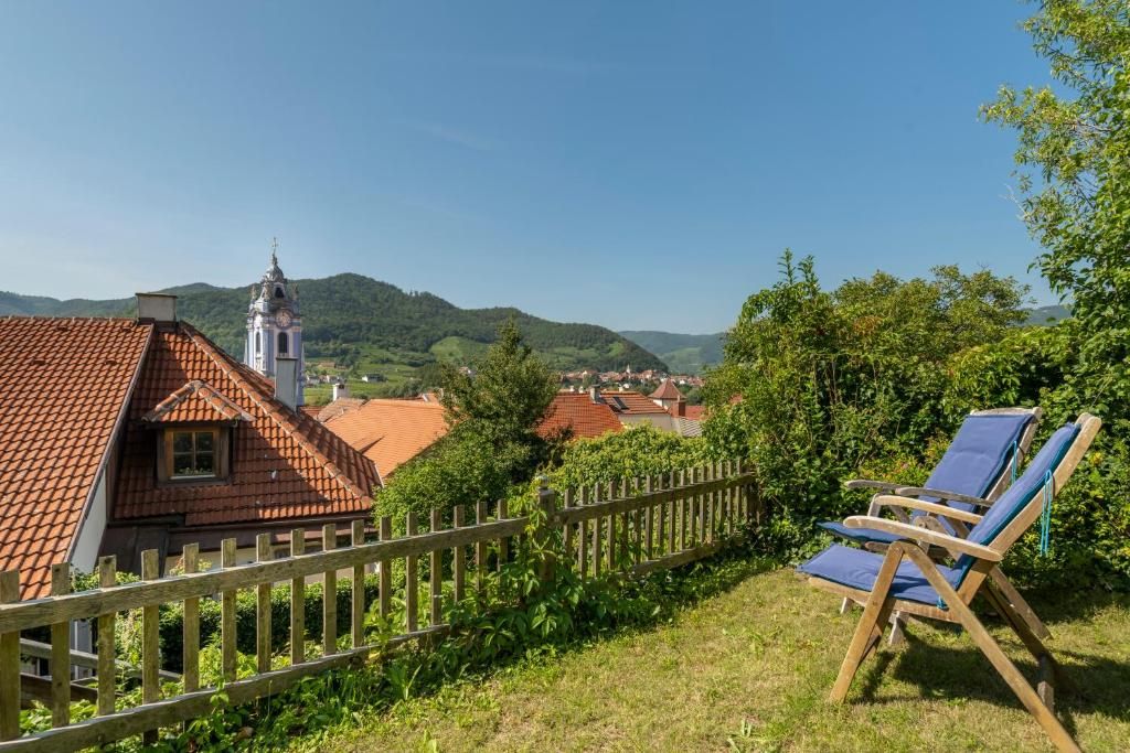 Blick auf Dürnstein mit Kirche und Liegestühlen im Vordergrund.