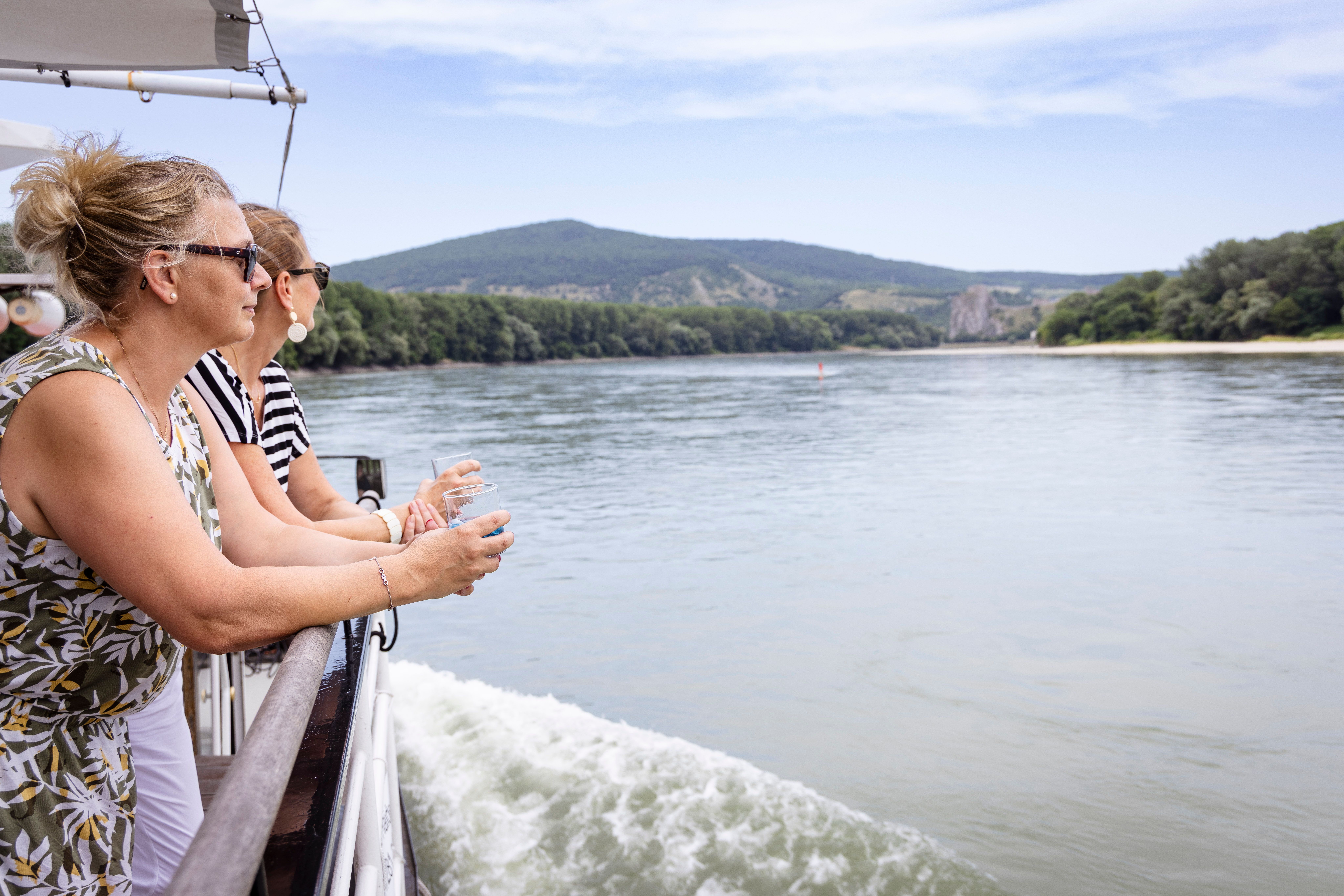 Zwei Damen auf einem Schiff schauen aufs Wasser