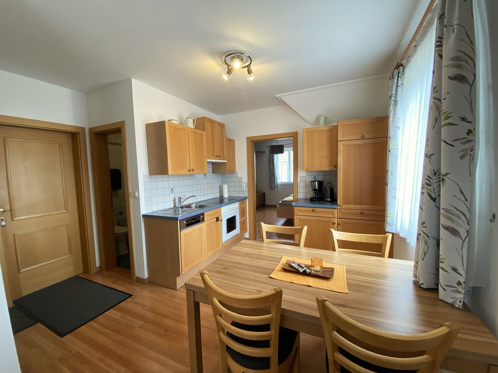 Innenansicht einer Ferienwohnung mit Küche und Esstisch.