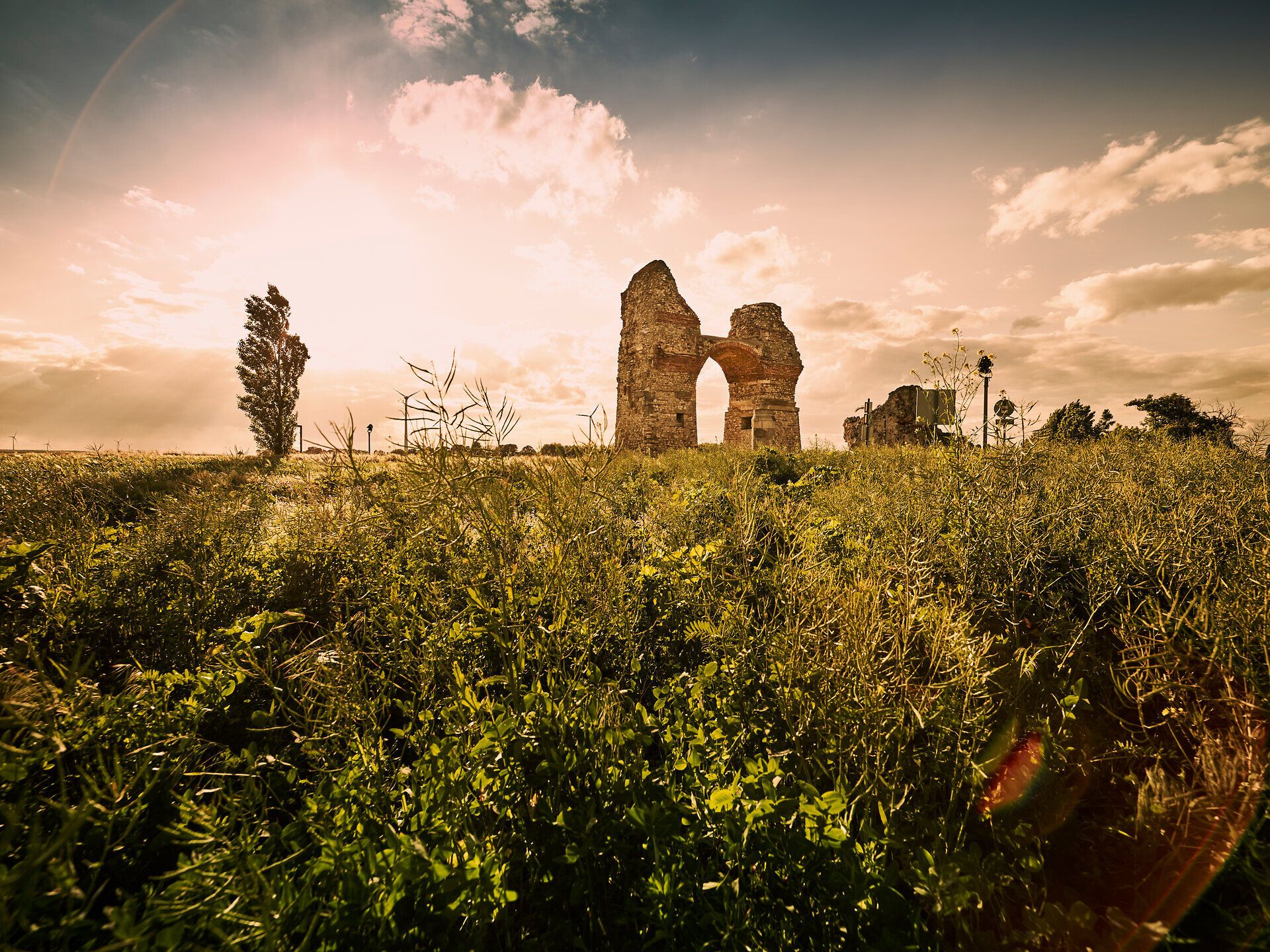 Die majestätischen Ruinen des Heidentors erheben sich stolz gegen den Himmel, umgeben von üppigem Grün und sanften Hügeln. Die warmen Sonnenstrahlen tauchen die Landschaft in ein goldenes Licht und laden dazu ein, die Geschichte und die atemberaubende Aussicht zu genießen.