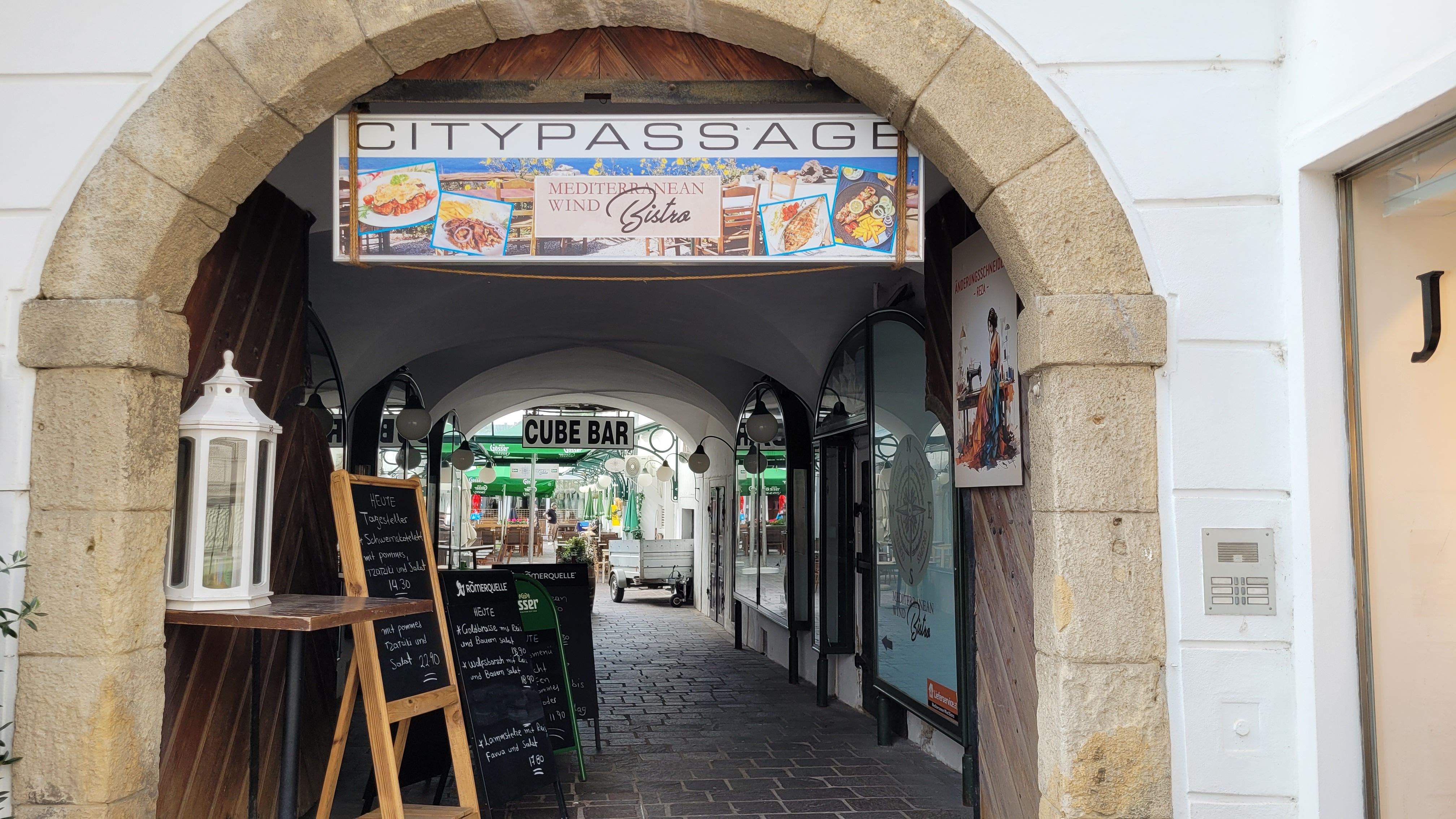 Eingang zur Citypassage mit Schildern für ein Bistro und eine Bar.