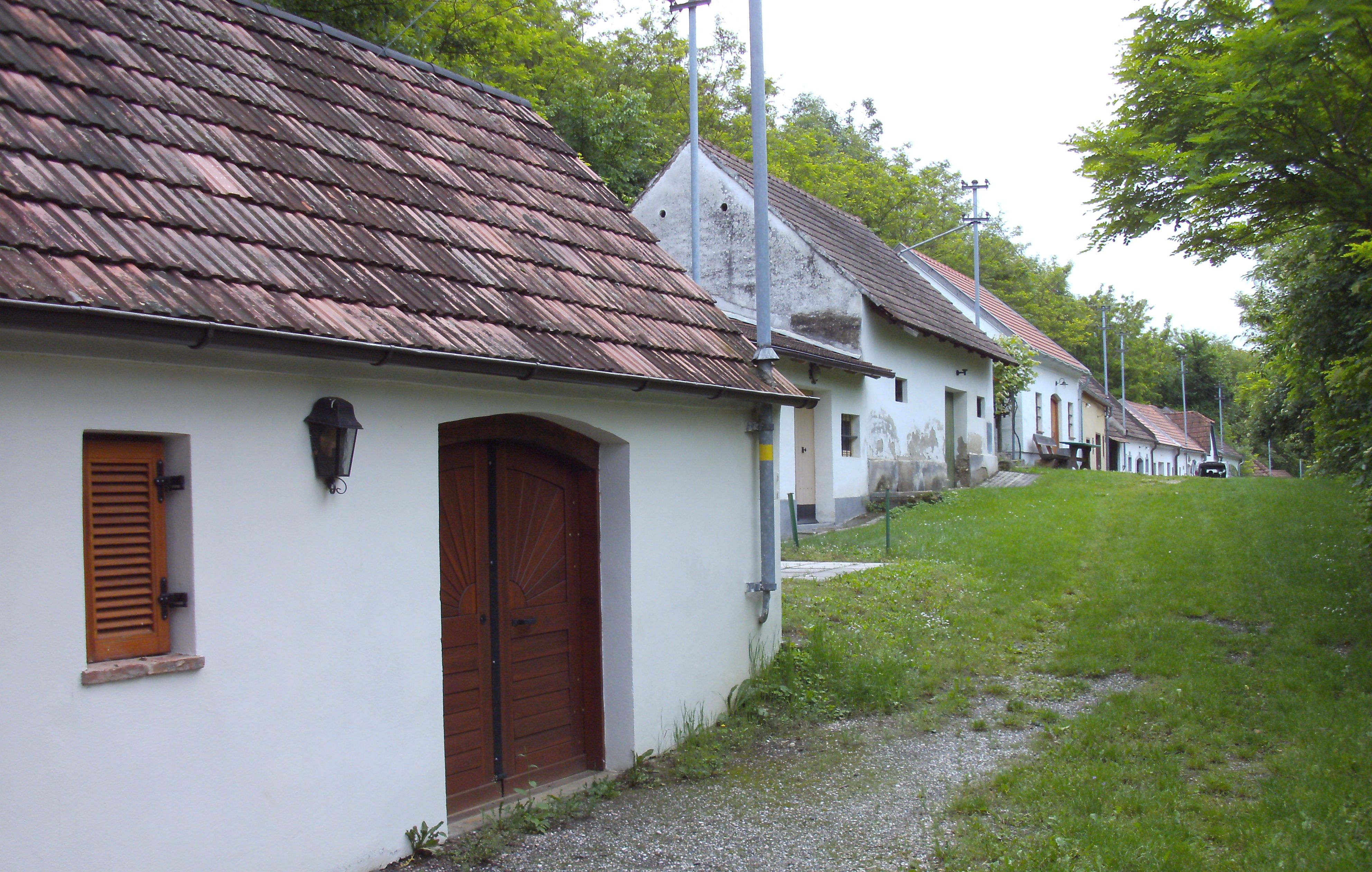 Reihe von Weinkellern in einer grünen Umgebung in Absdorf.
