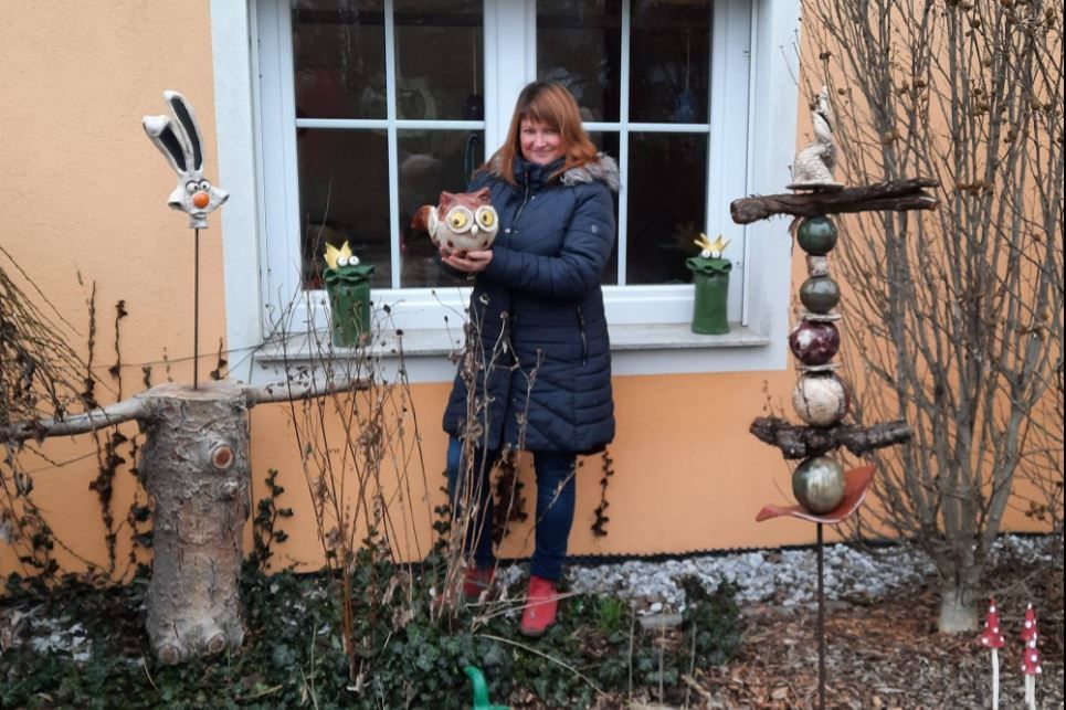 Portrait of a ceramist in front of her workshop.