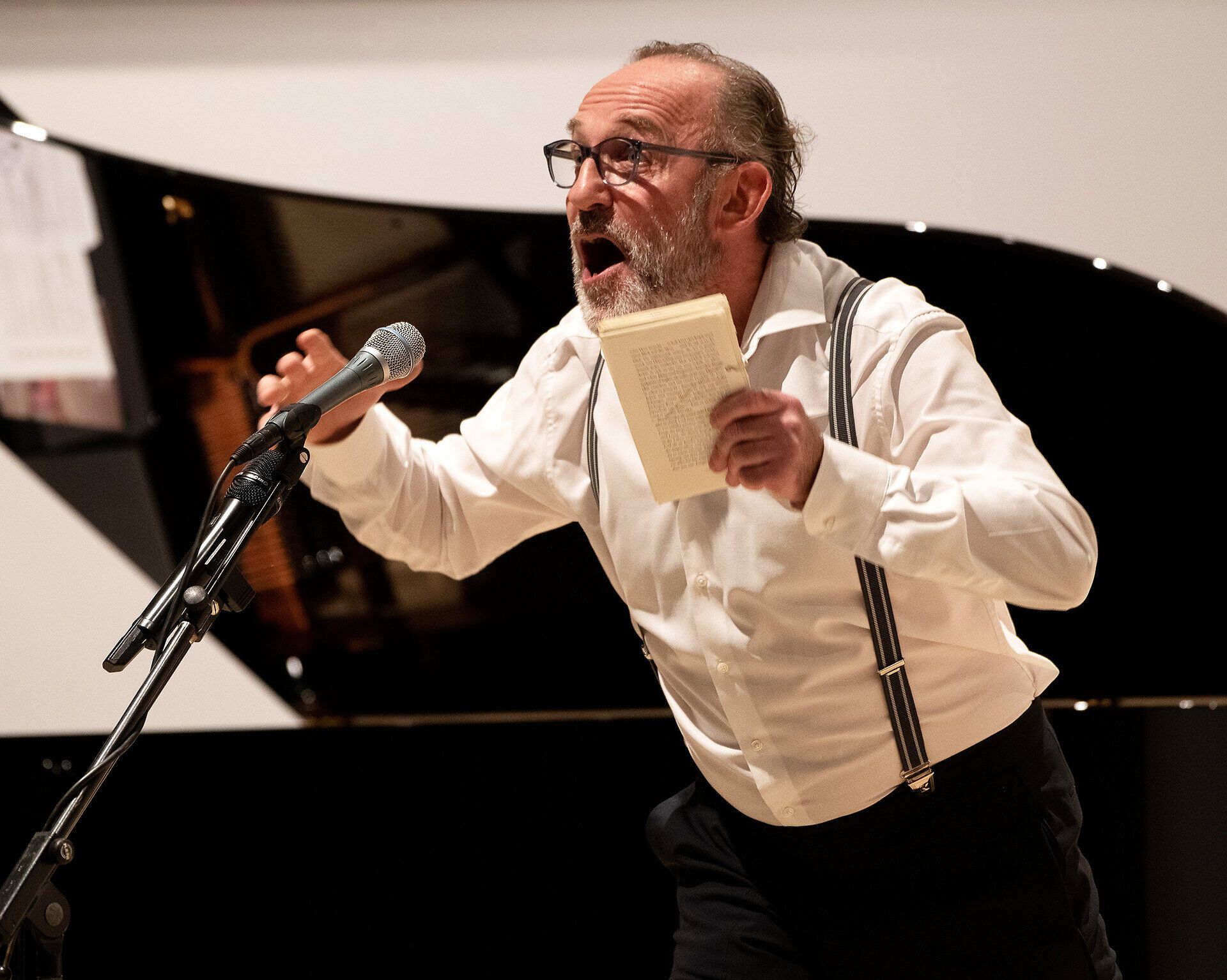 Ein leidenschaftlicher Künstler fesselt das Publikum mit seiner Darbietung, während die sanften Klänge des Klaviers im Hintergrund eine harmonische Atmosphäre schaffen. Die Verbindung von Musik und Poesie lässt die Zuschauer in eine Welt voller Emotionen eintauchen und verspricht unvergessliche Momente.