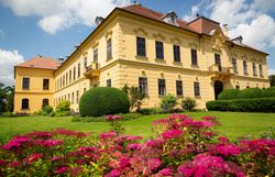 Umgeben von üppigen Gärten und blühenden Pflanzen strahlt das Schloss eine majestätische Ruhe aus. Die harmonische Verbindung von Architektur und Natur lädt dazu ein, die Seele baumeln zu lassen und die Schönheit der Umgebung zu genießen.