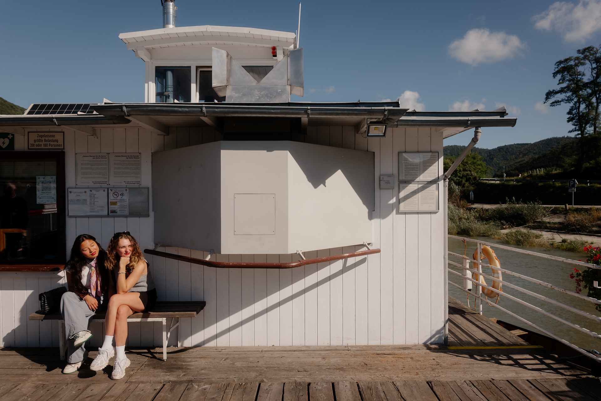 Zwei Frauen sitzen auf einer Rollfähre auf der Donau