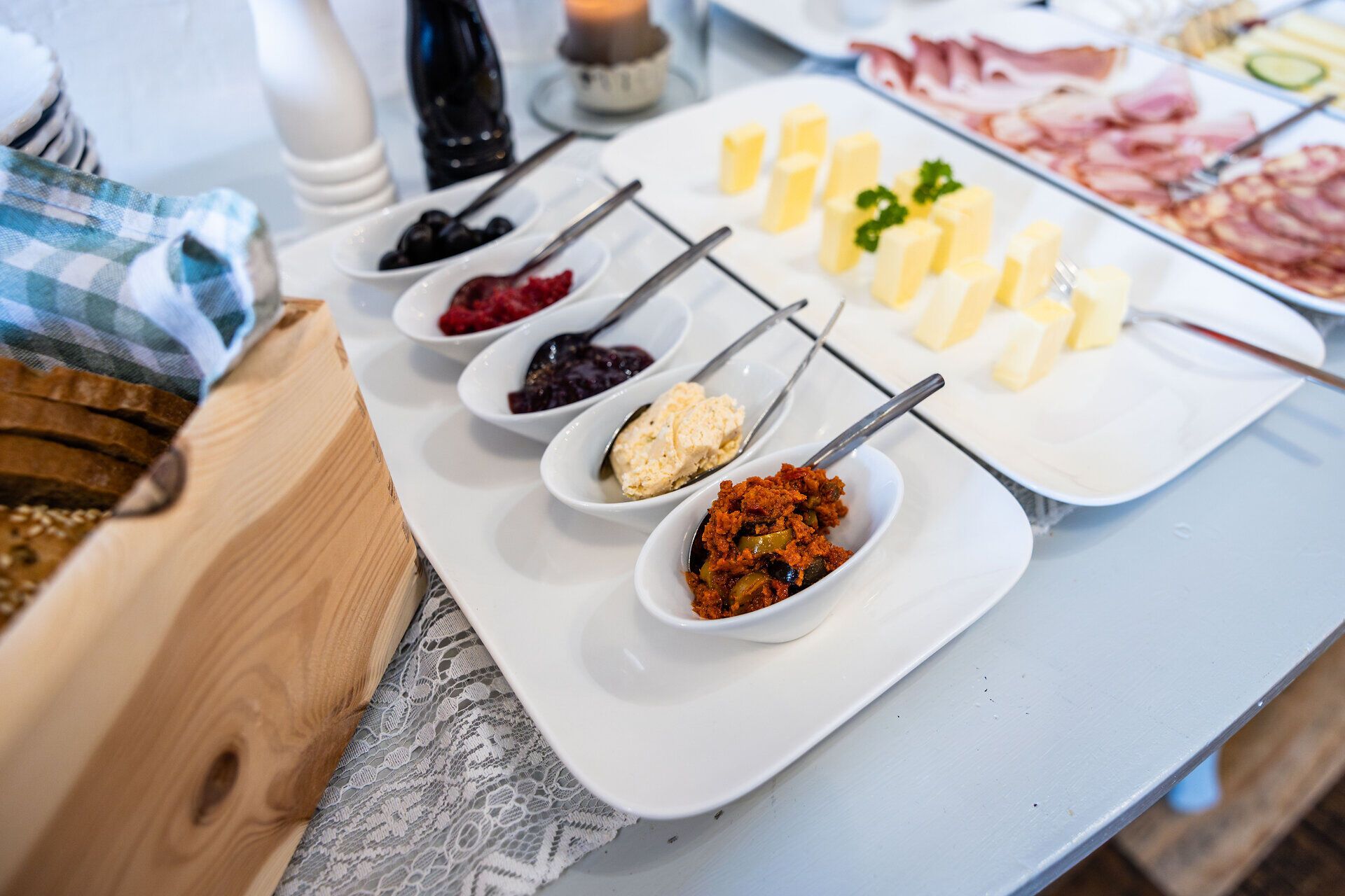 Ein Teil eines Frühstücksbuffets mit weißen Tellern und Schüsselchen mit verschiedenen Speisen.