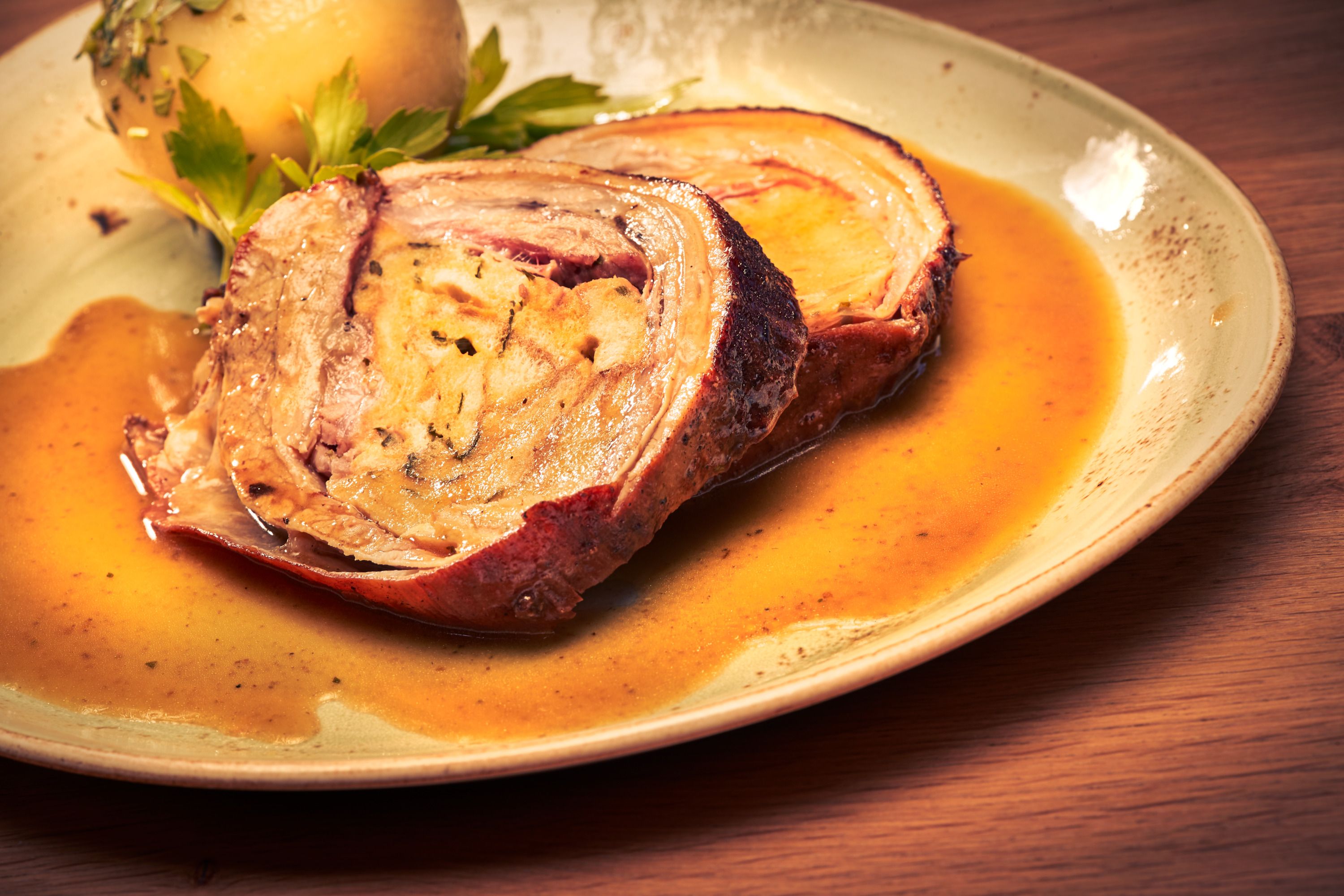 Ein Teller mit Braten und Kartoffel in Soße.