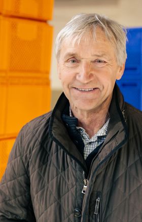 Spargelbauer Werner Magoschitz. Im Hintergrund stehen bunte Kisten. 