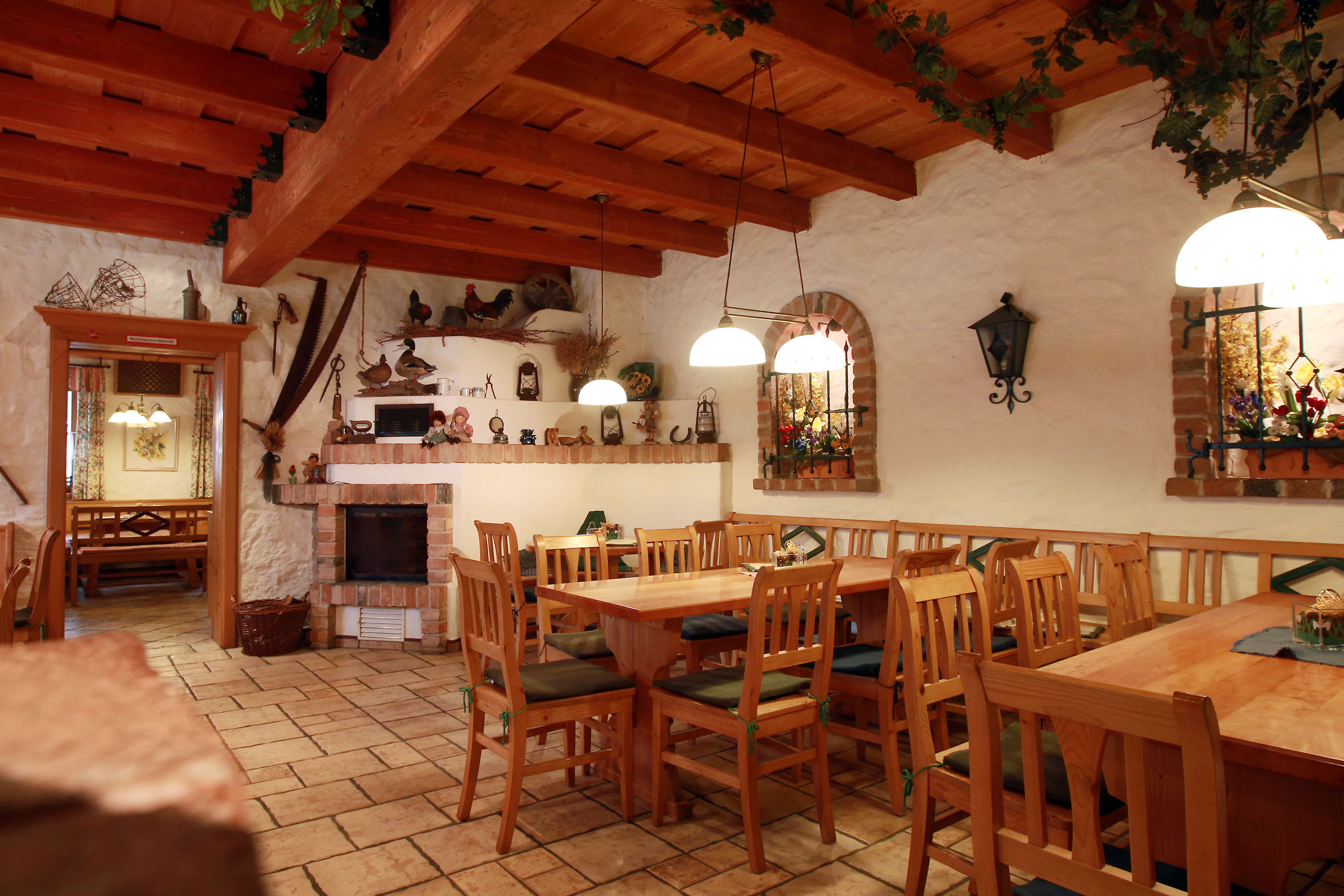Gemütlicher Gastraum mit Holzmöbeln und rustikaler Dekoration.
