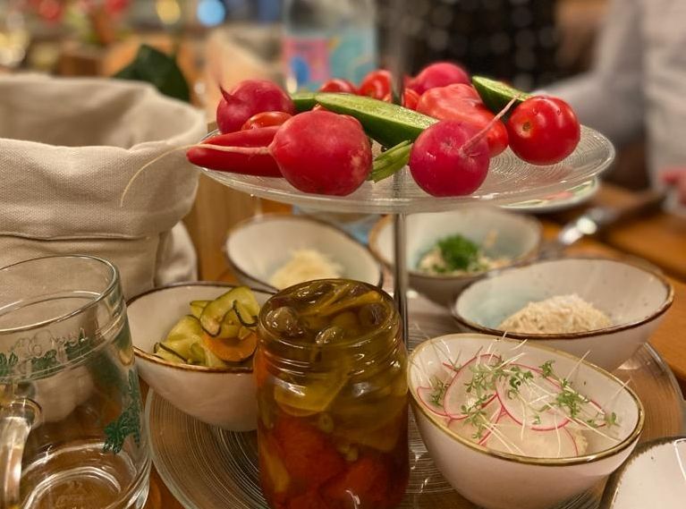 Ein Tisch mit verschiedenen Schalen voller Gemüse und eingelegten Speisen.