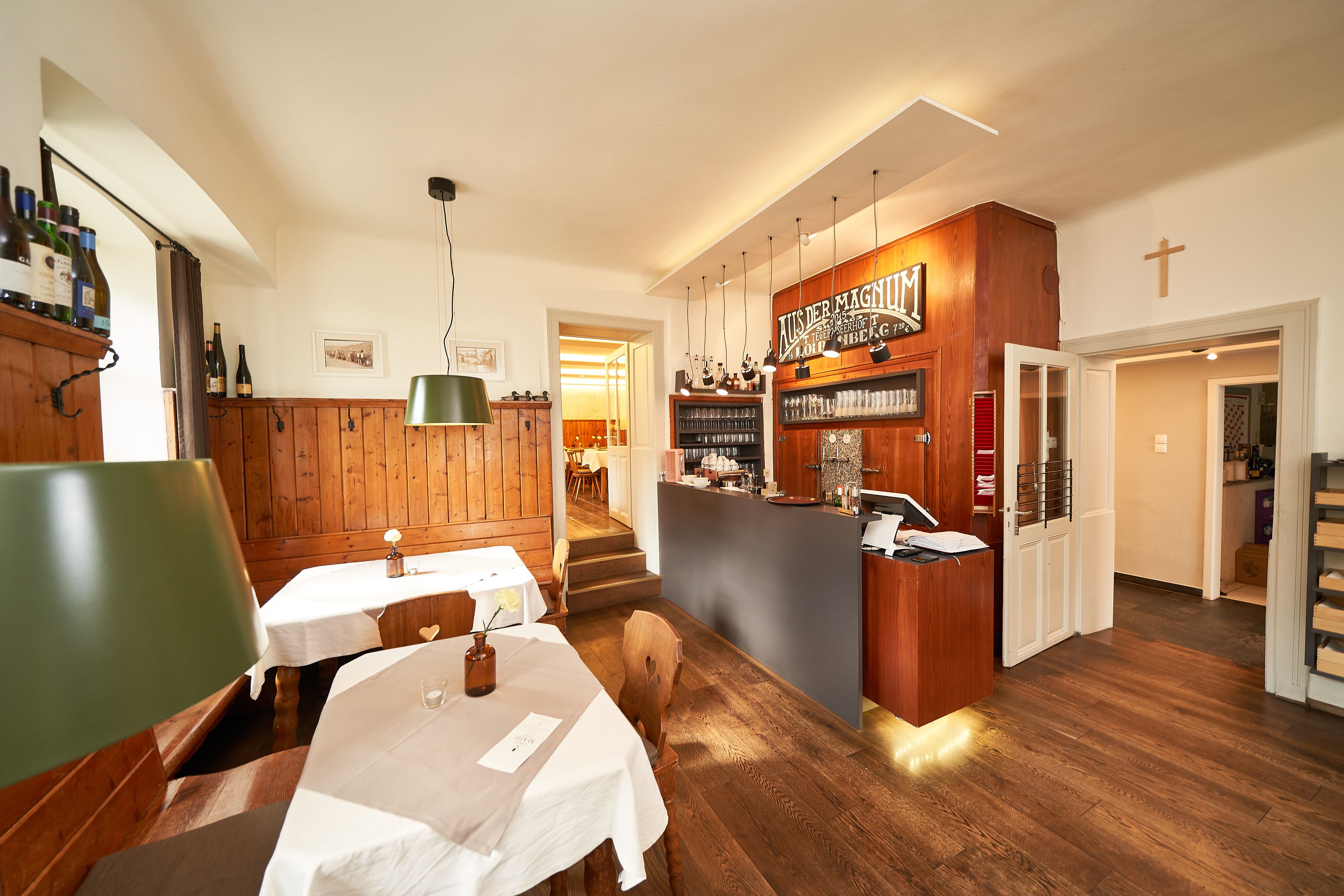 Innenansicht eines gemütlichen Gastraums mit Holzmöbeln und Theke.