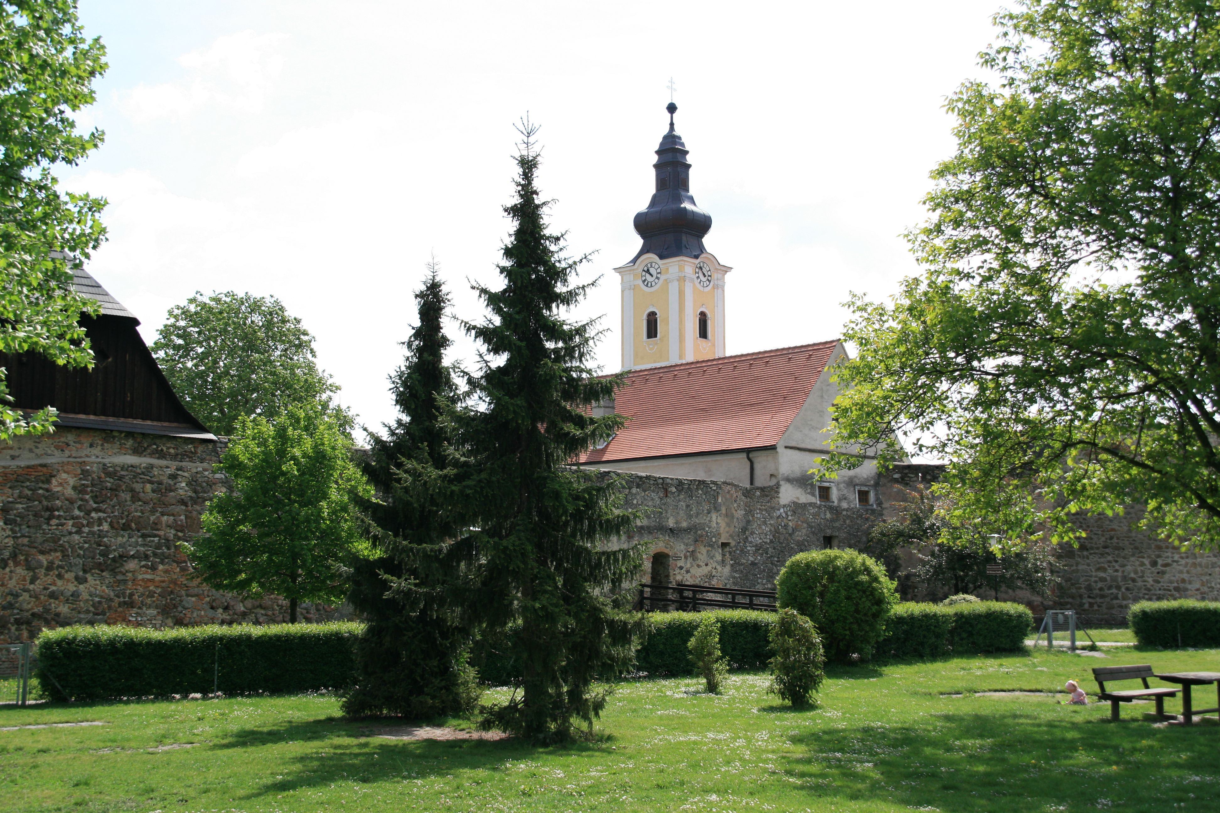 Mautern parish church with church tower and garden in the foreground.