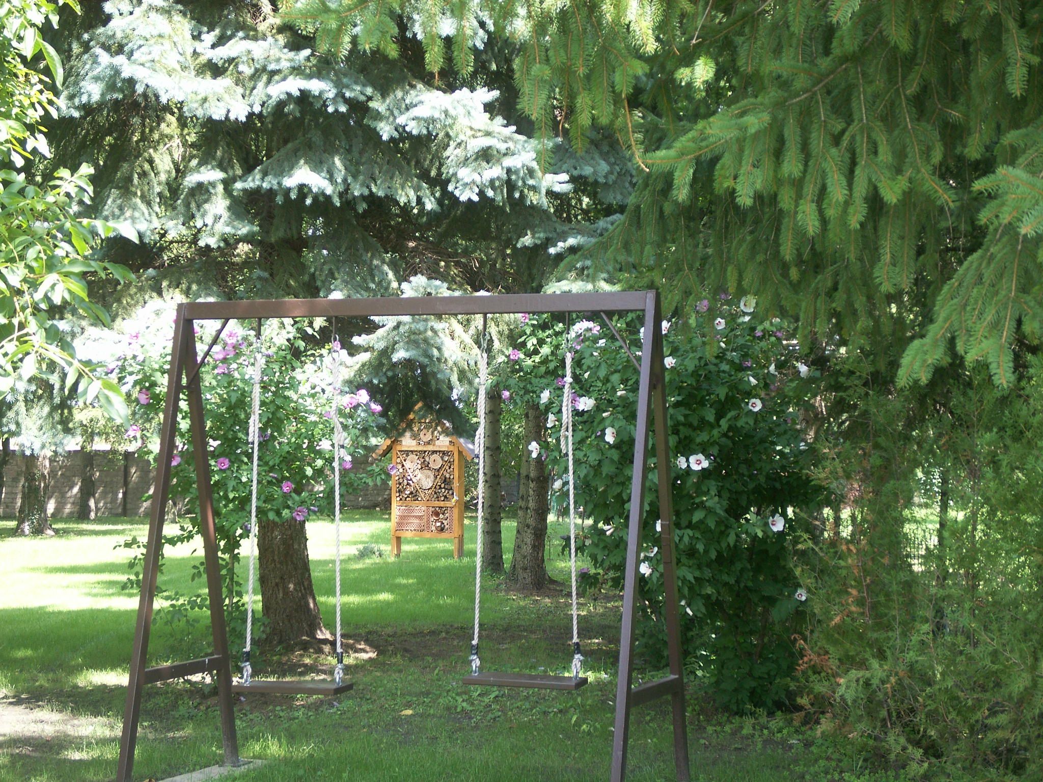 Zahrada s houpačkou a hmyzím hotelem.