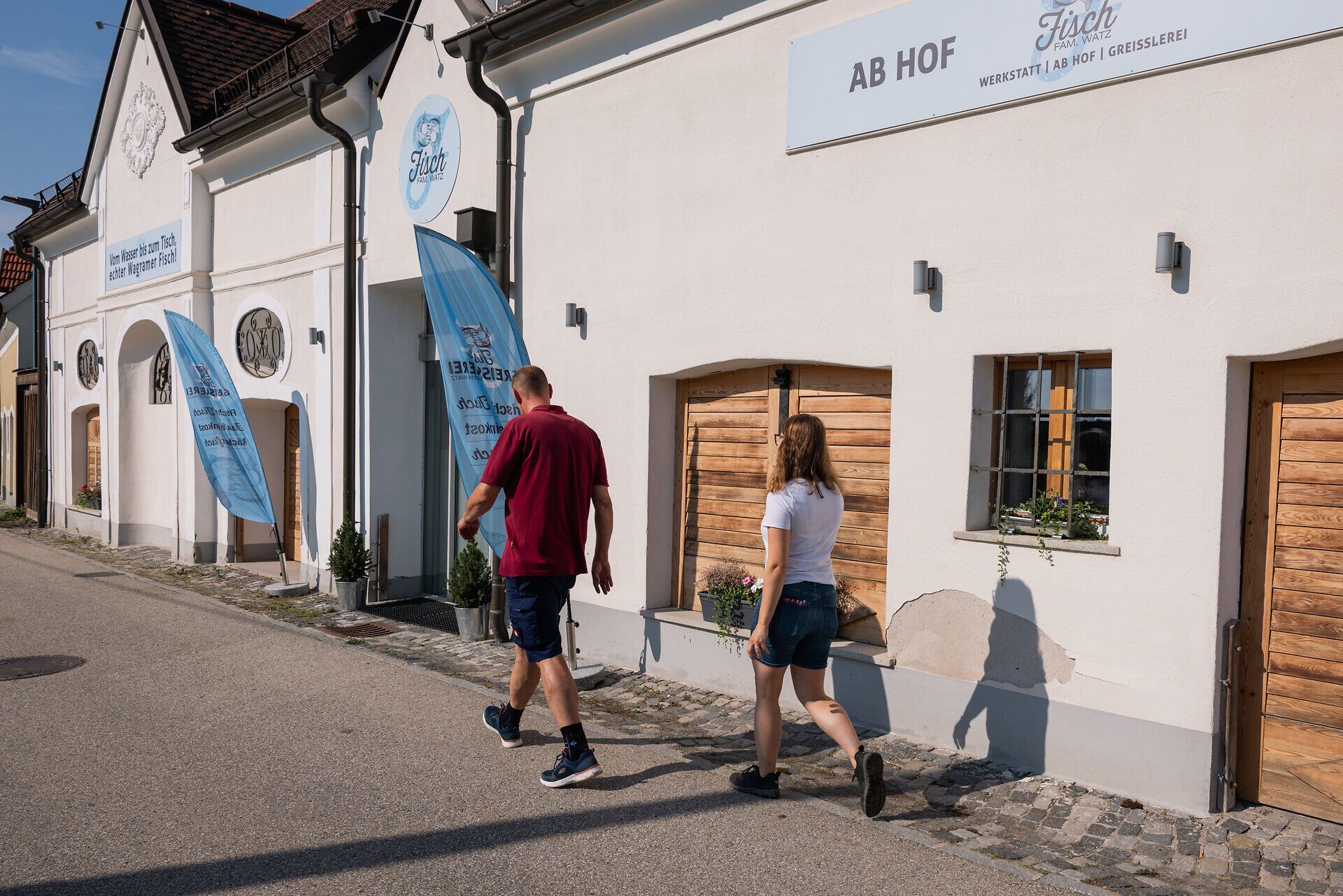 Zwei Personen vor dem Ab-Hof-Verkauf der Fisch-Greisslerei.