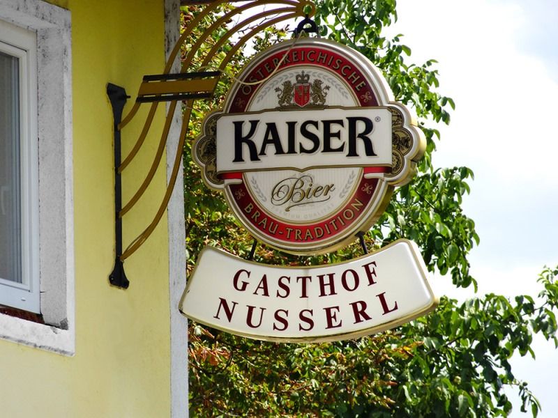 Schild des Gasthofs Nusserl mit Kaiser Bier Logo.