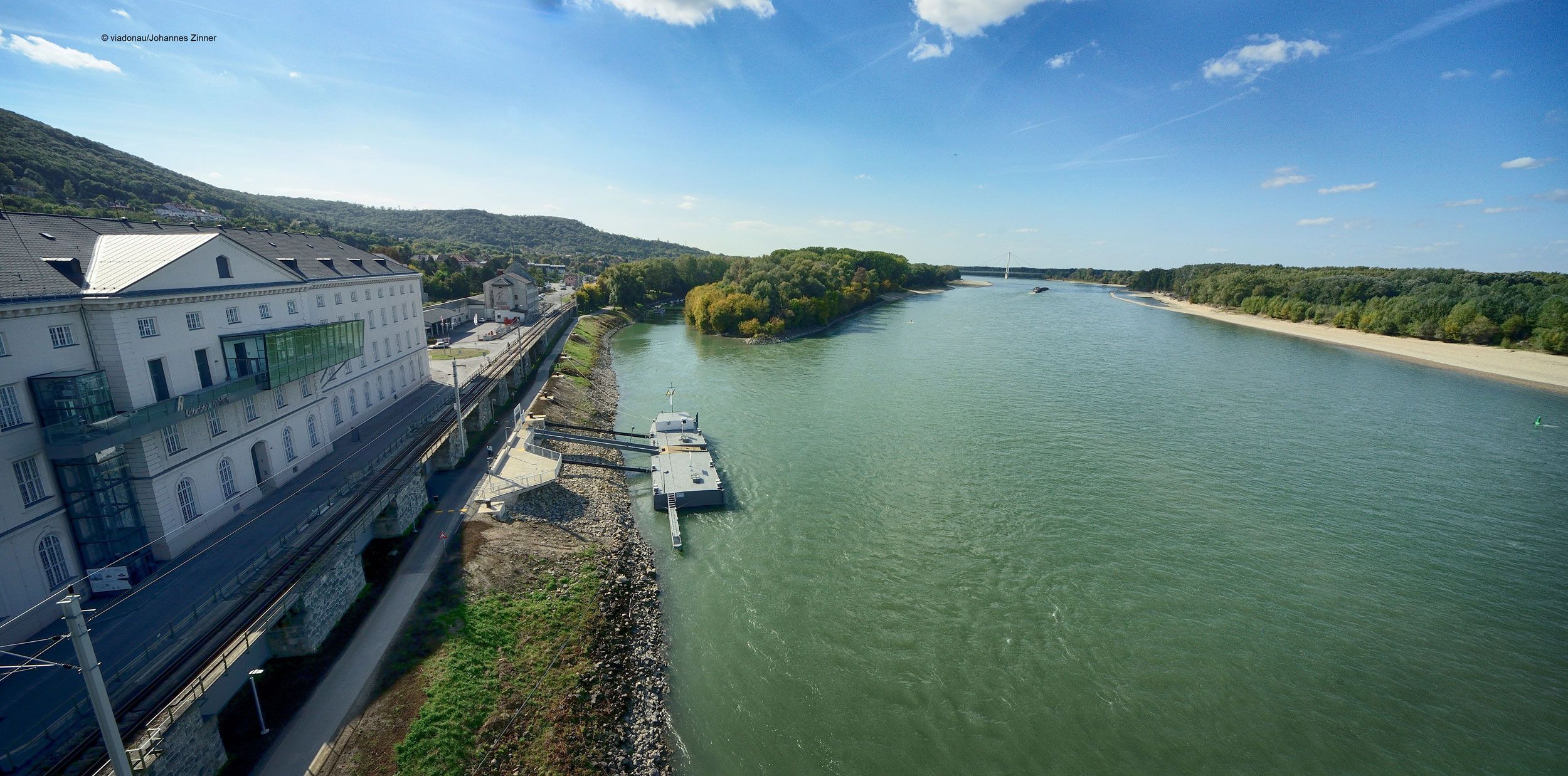 Blick auf die Donau bei Hainburg mit Anlegestelle und Gebäuden am Ufer.