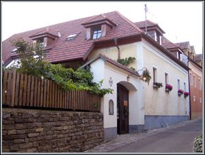Ein traditionelles Haus mit roten Dachziegeln und Blumen an den Fenstern.