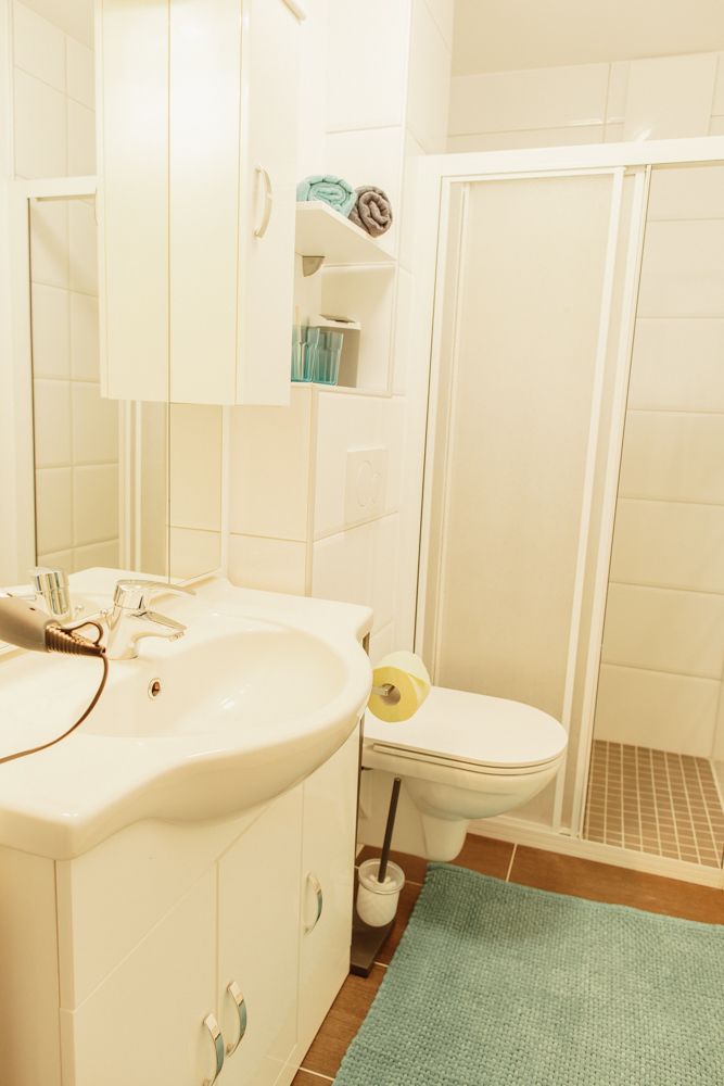 Modernes Badezimmer mit Waschbecken, Toilette und Dusche.