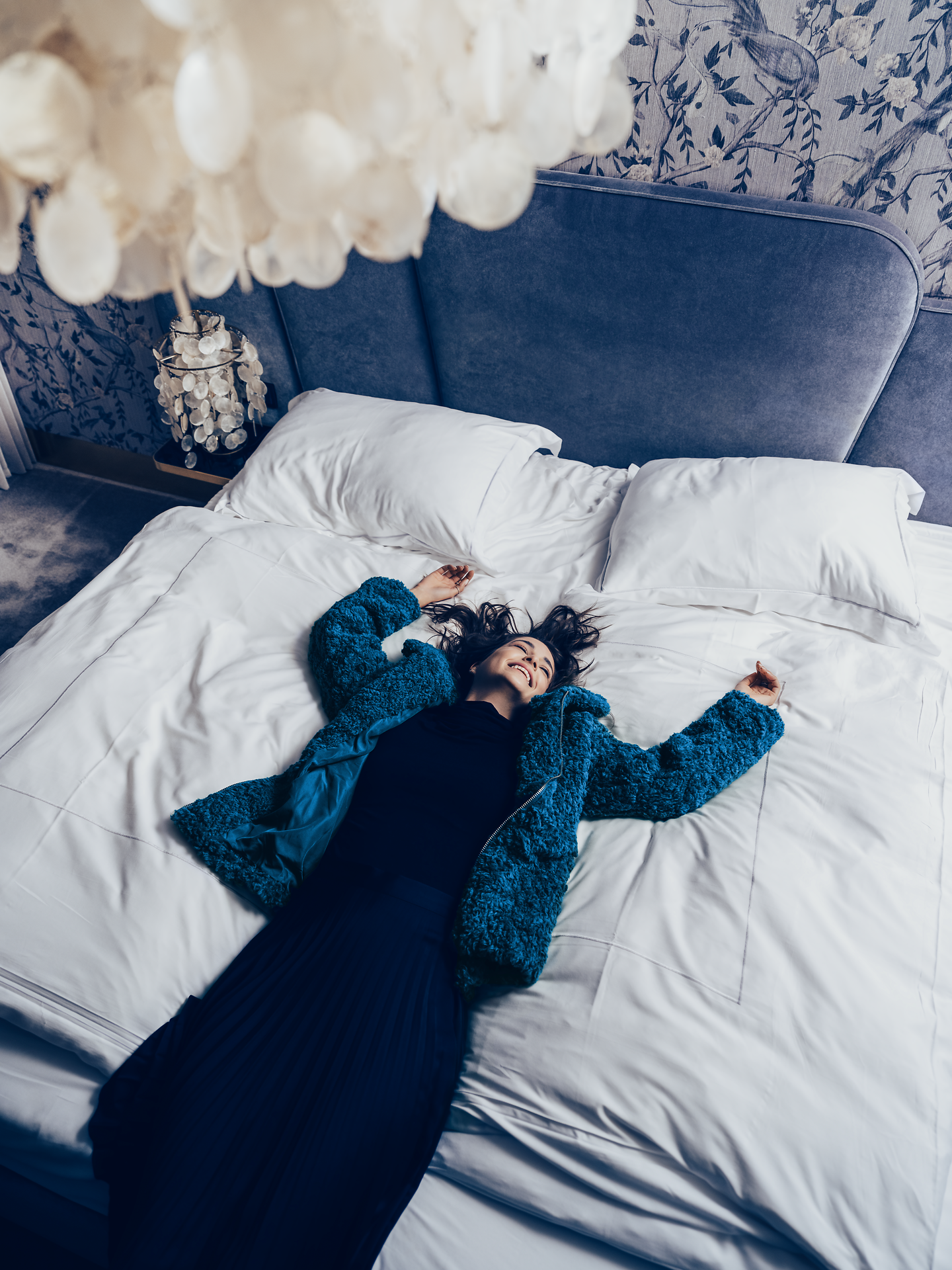 In einem stilvollen Hotelzimmer lädt das große Bett mit frischen, weißen Laken zum Entspannen ein. Die sanften Farben und die gemütliche Atmosphäre schaffen einen perfekten Rückzugsort, um die Schönheit der Wiener Alpen zu genießen.