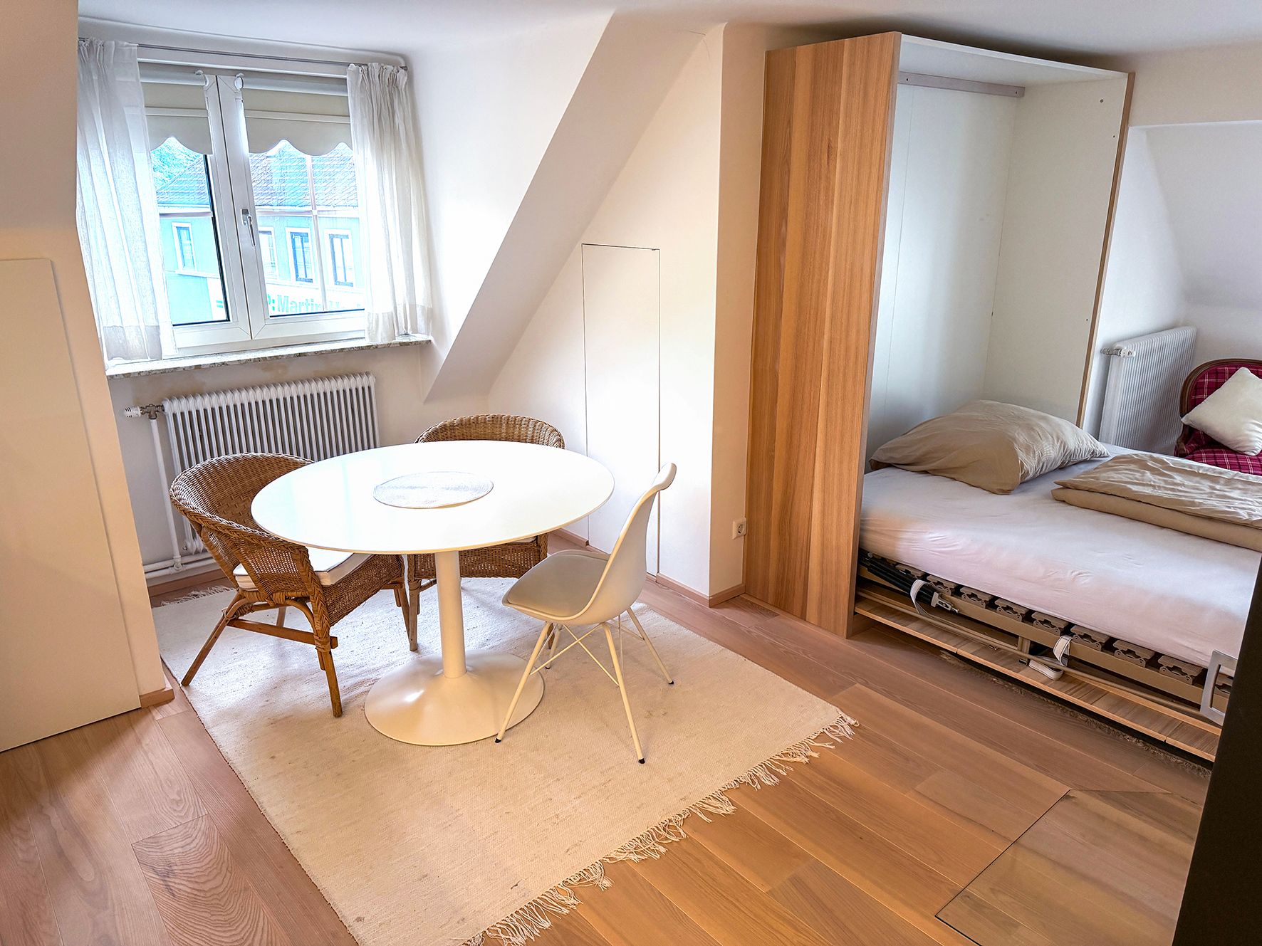 A white table with two chairs in an apartment
