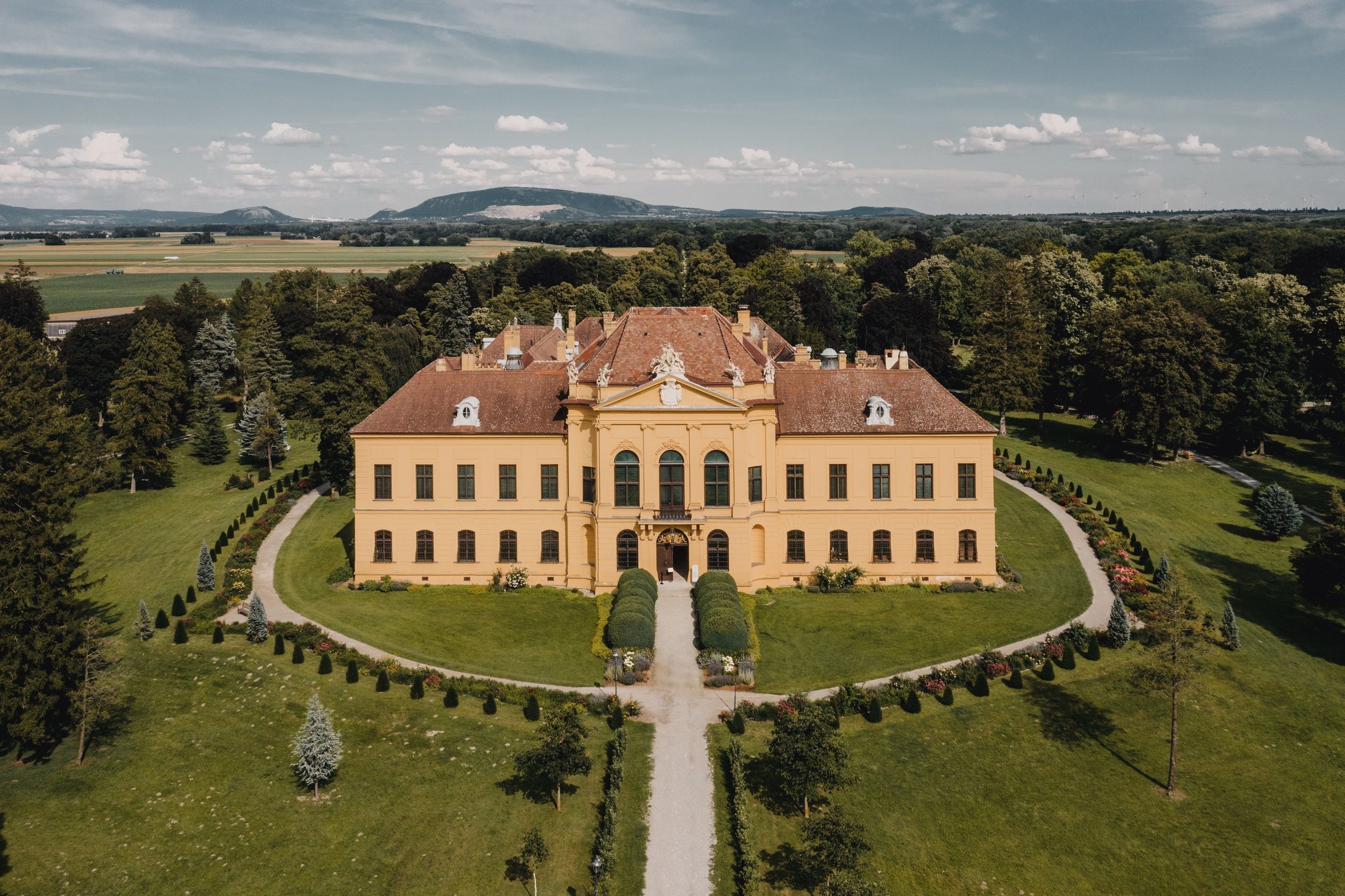 Luftaufnahme von Schloss Eckartsau umgeben von grüner Landschaft.