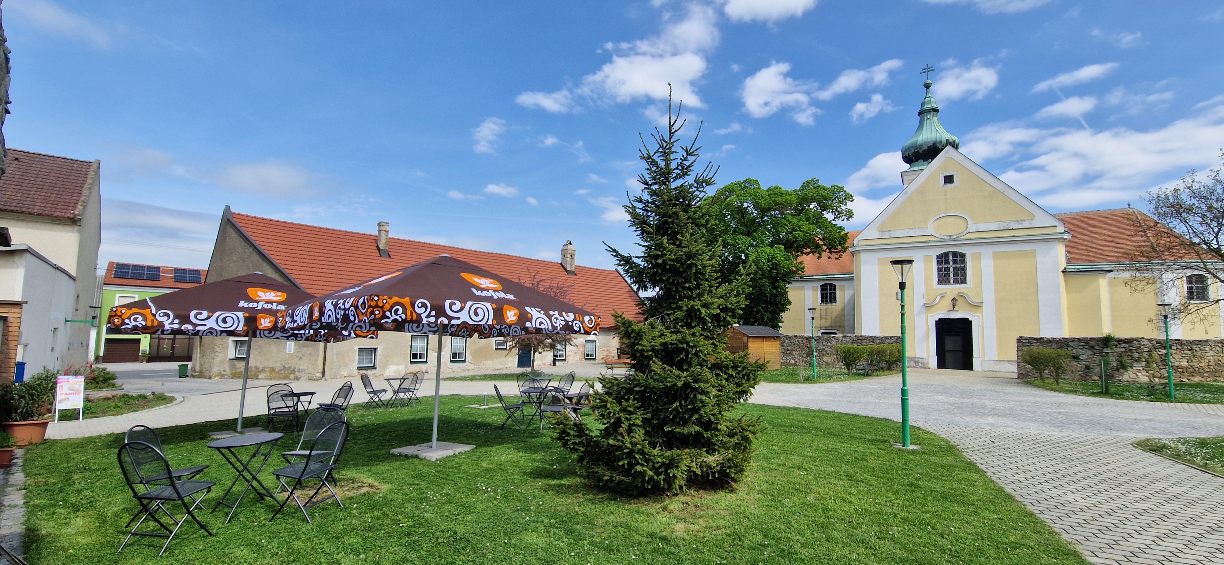 WunderBar Wolfsthal Garten mit Tischen, Sesseln und Sonnenschirmen