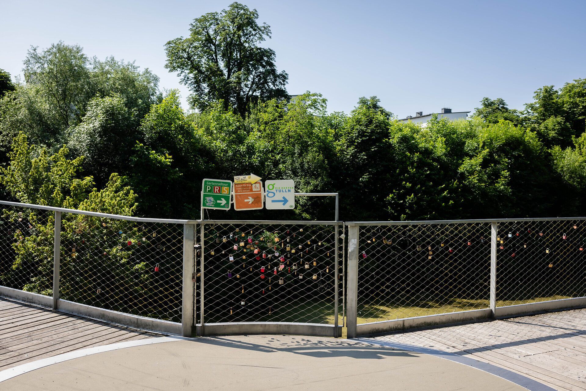 Rosenbrücke mit Radweg-Tafeln und vielen Glück-Schlössern am Gitter