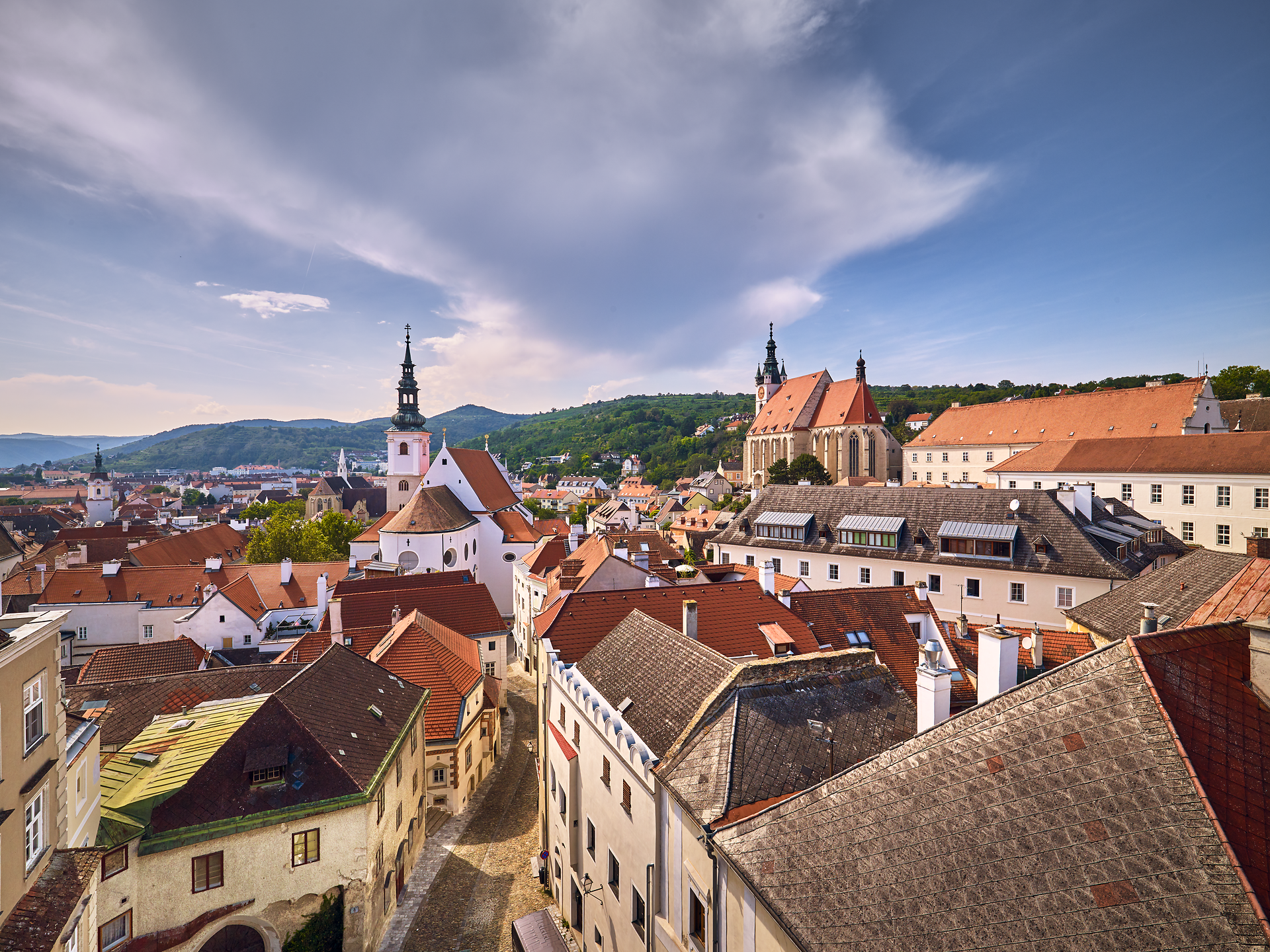 Die malerische Kulisse der Kunstmeile Krems vereint historische Architektur mit zeitgenössischer Kunst. Die Dominikanerkirche erhebt sich majestätisch über die charmanten Gassen, während die Donau sanft im Hintergrund fließt und eine friedliche Atmosphäre schafft.
