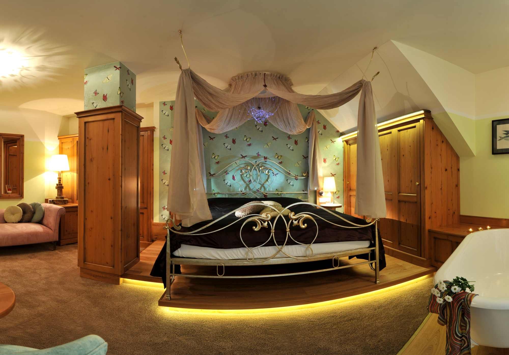 Ein luxuriöses Schlafzimmer mit Himmelbett, Holzmöbeln und Badewanne.