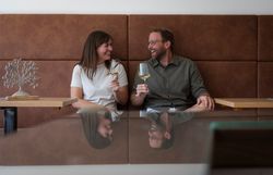 Marie-Theres Essl und Niko Rehrl-Fischer stoßen mit einem Glas Wein an