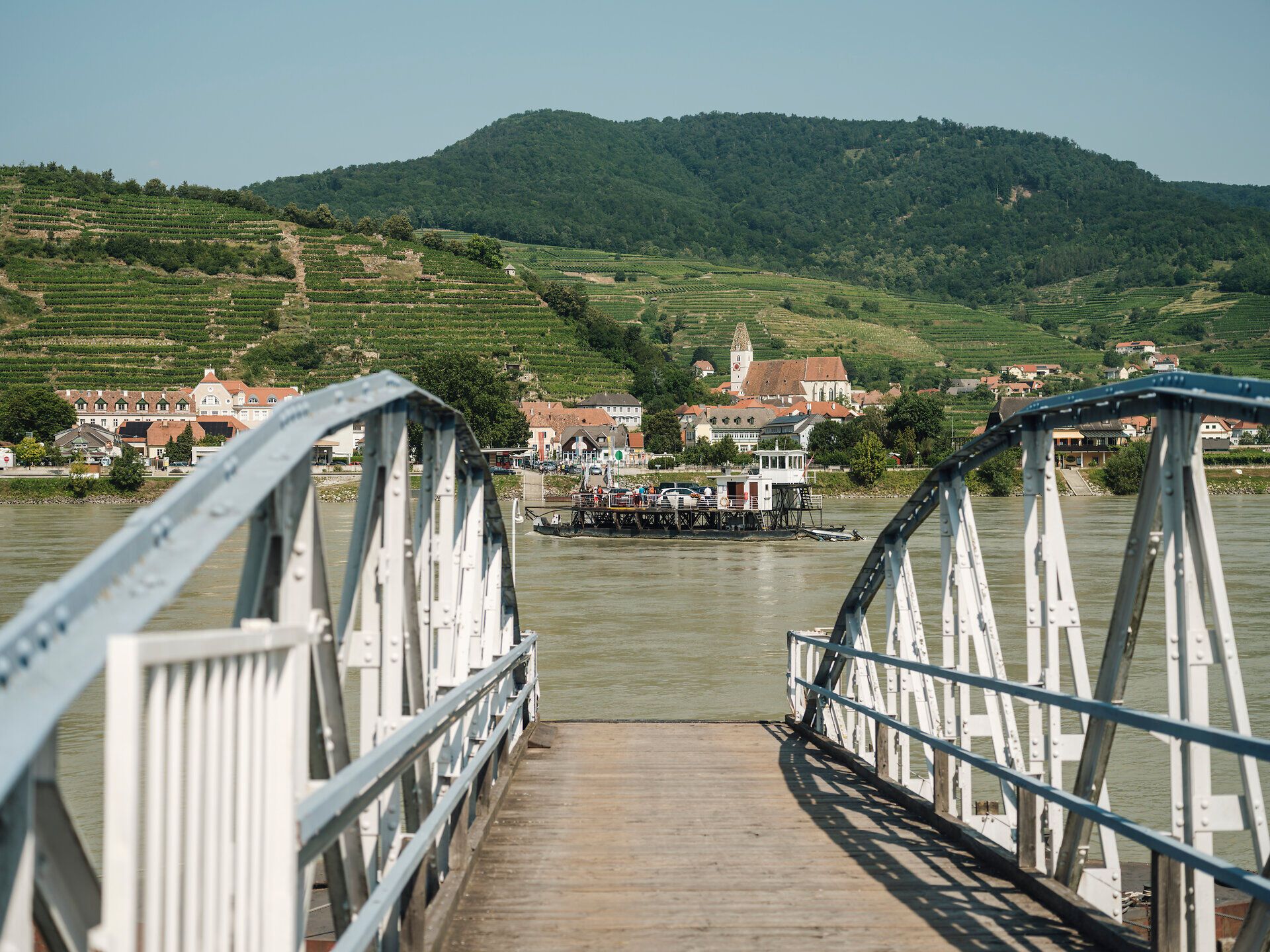 Die Brücke zur Rollfähre im Vordergrund und im Hintergrund die Donau mit der Rollfähre vor Spitz.