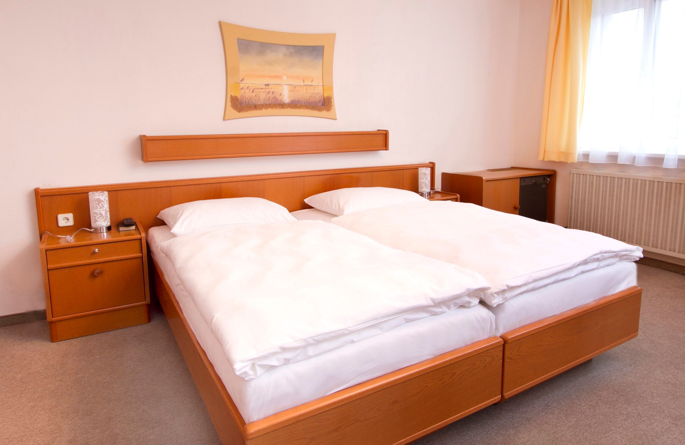 Ein Hotelzimmer mit einem Doppelbett, Holzmöbeln und einem Bild an der Wand.