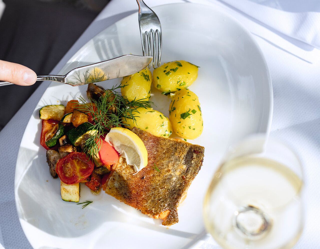 Fischgericht und Kartoffeln auf einem weißen Teller. 