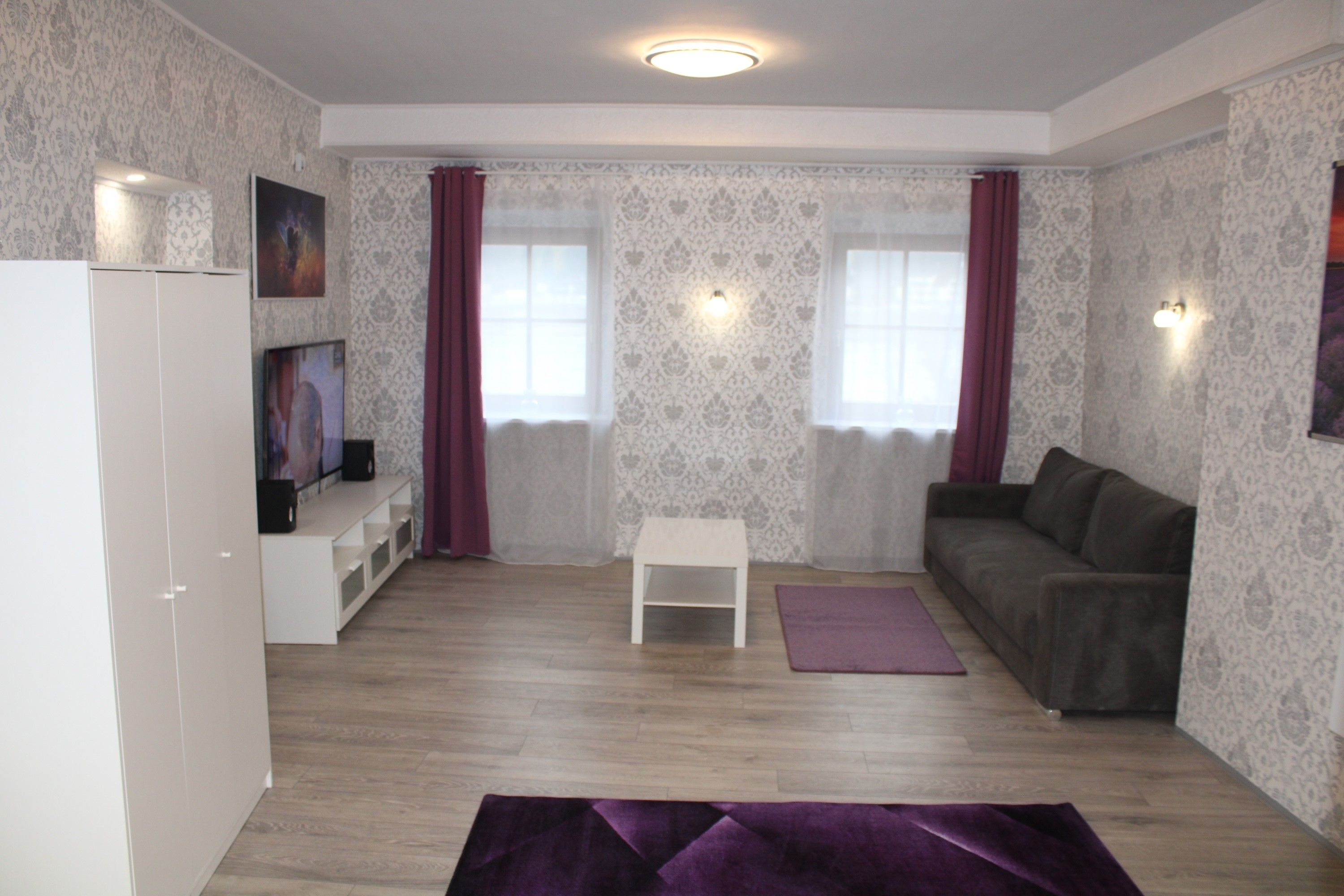 Wohnzimmer mit weißen Möbeln und grauer Couch