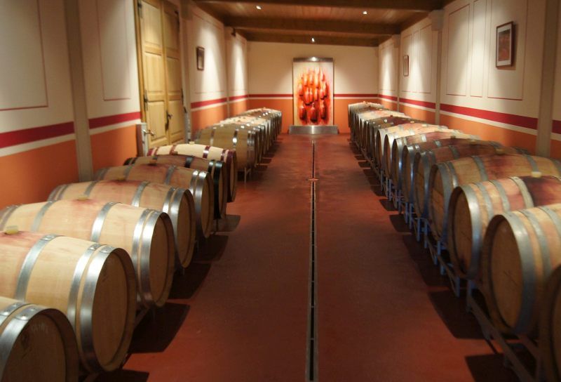 Weinkeller mit Holzfässern auf beiden Seiten eines Ganges.