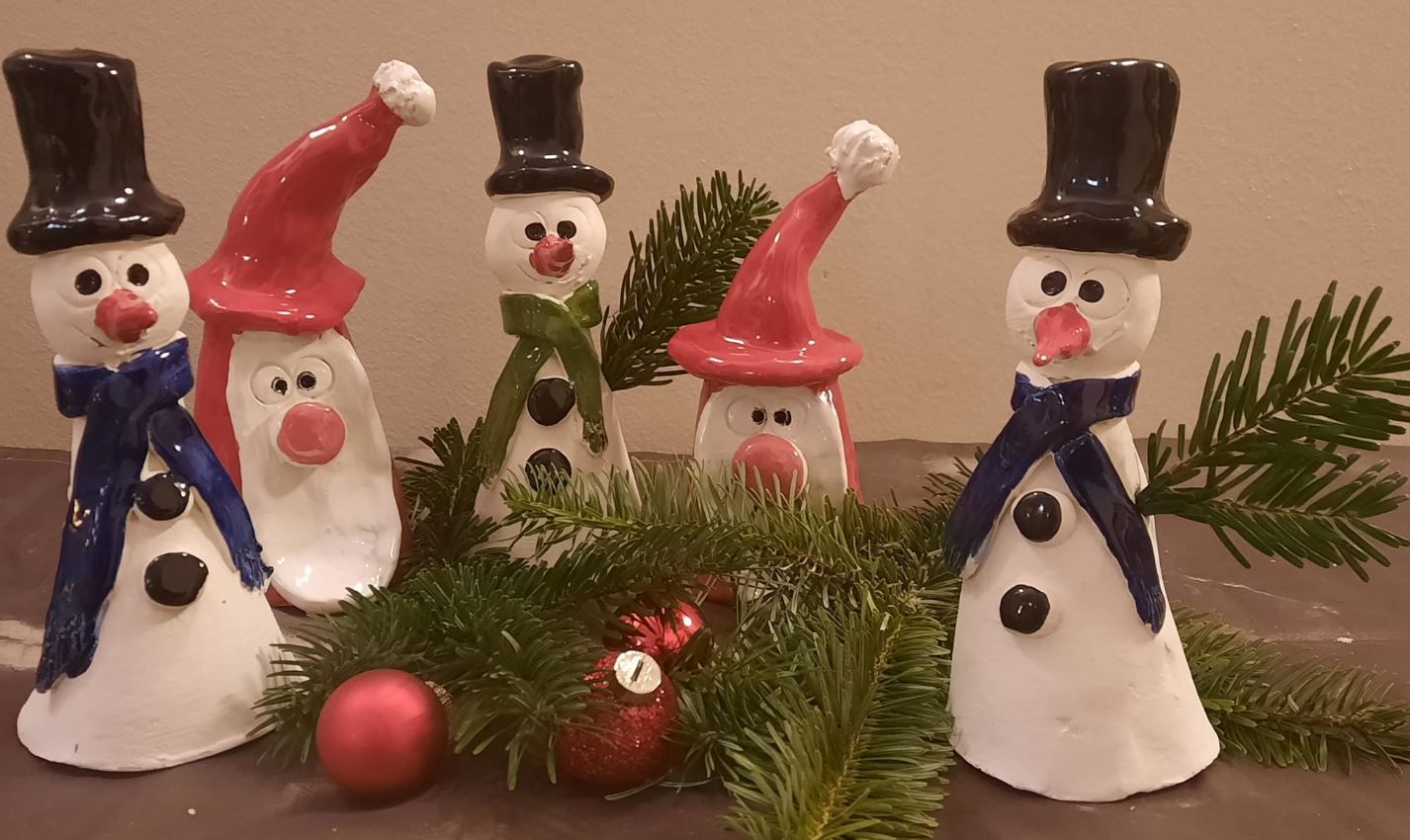 Handmade ceramic snowmen as winter decorations.