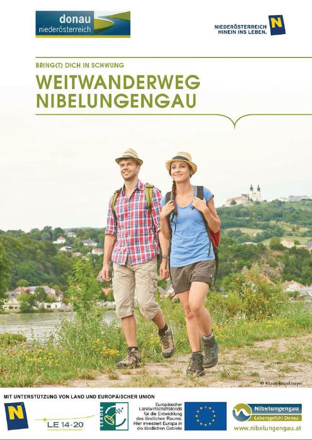 Eine Frau und ein Mann unterwegs auf em Weitwanderweg Nibelungengau mit Maria Taferl und der Donau im Hintergrund.