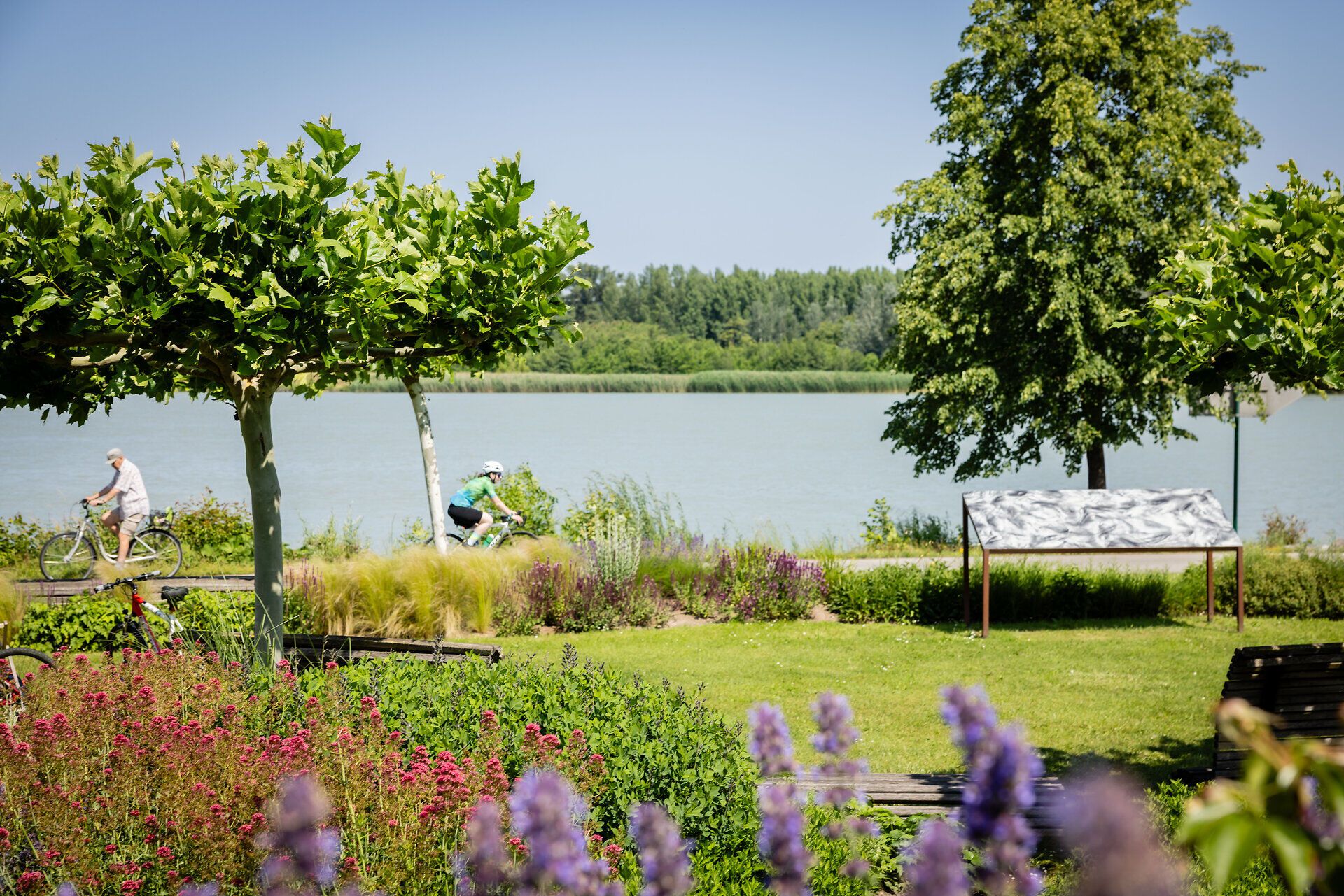 Donaulände Tulln mit Blick auf die Donau und zwei Radfahrern
