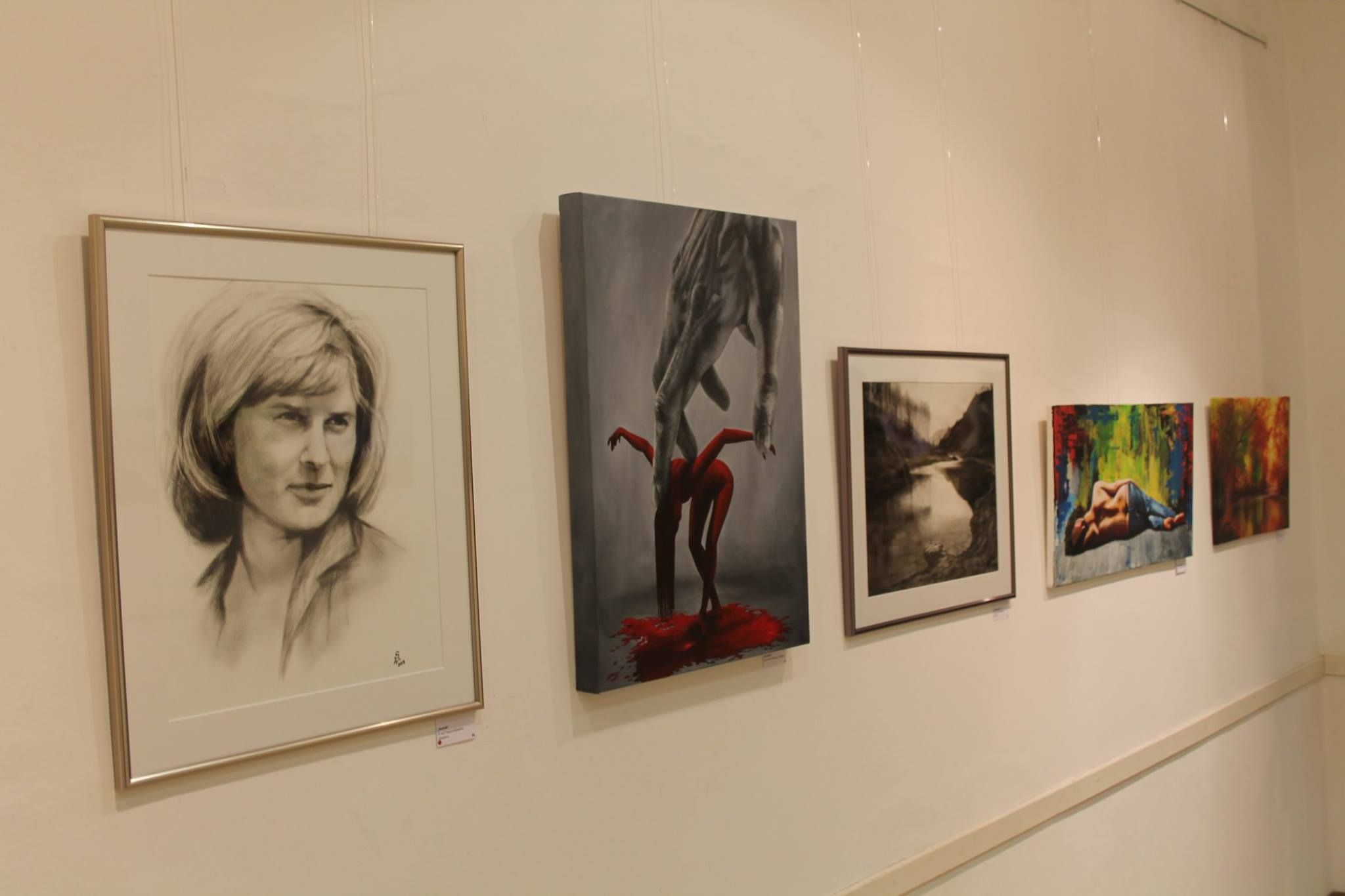 Egy galéria fehér falán öt műalkotás lóg.