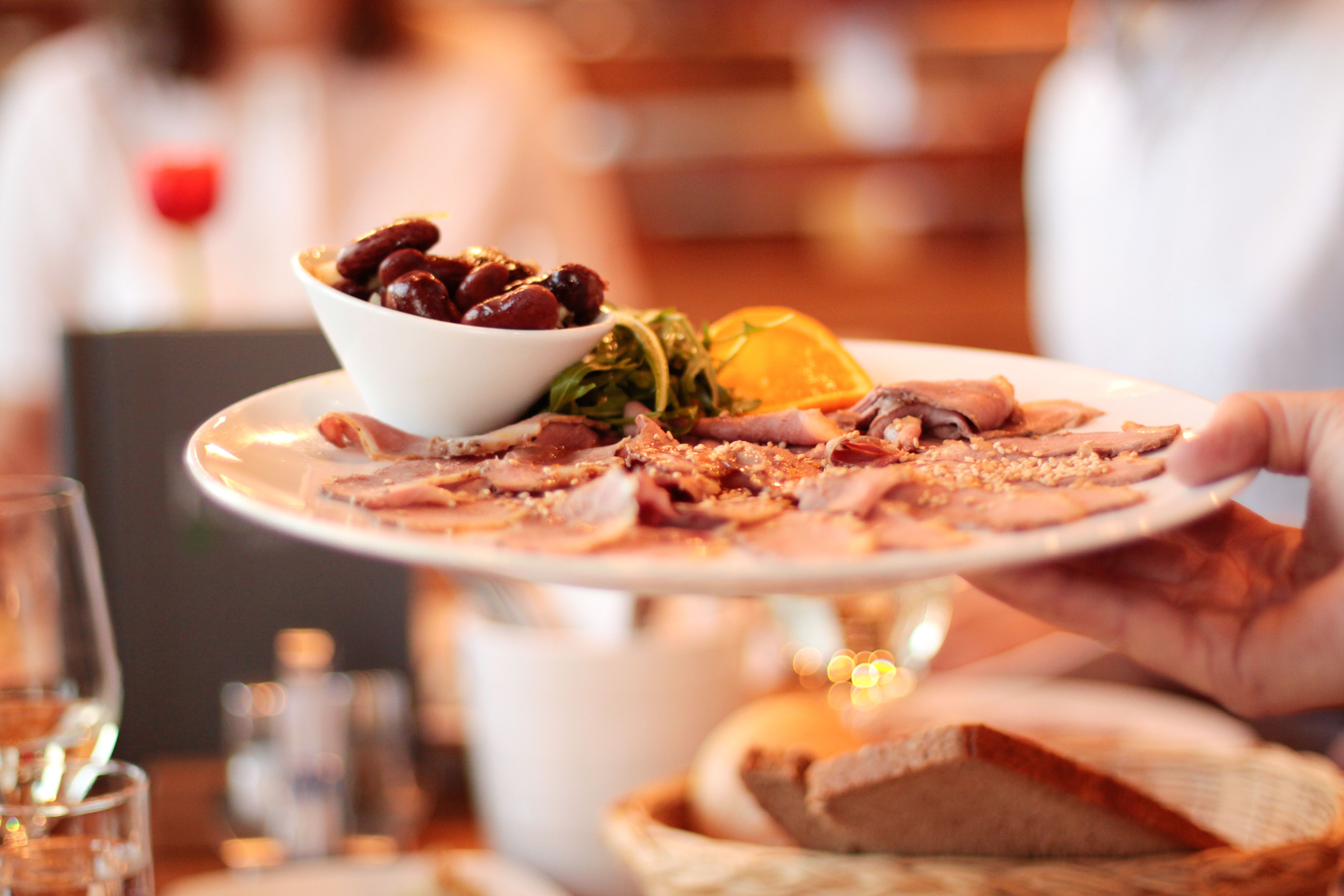 Ein Teller mit Aufschnitt und Oliven wird in einem Restaurant serviert.