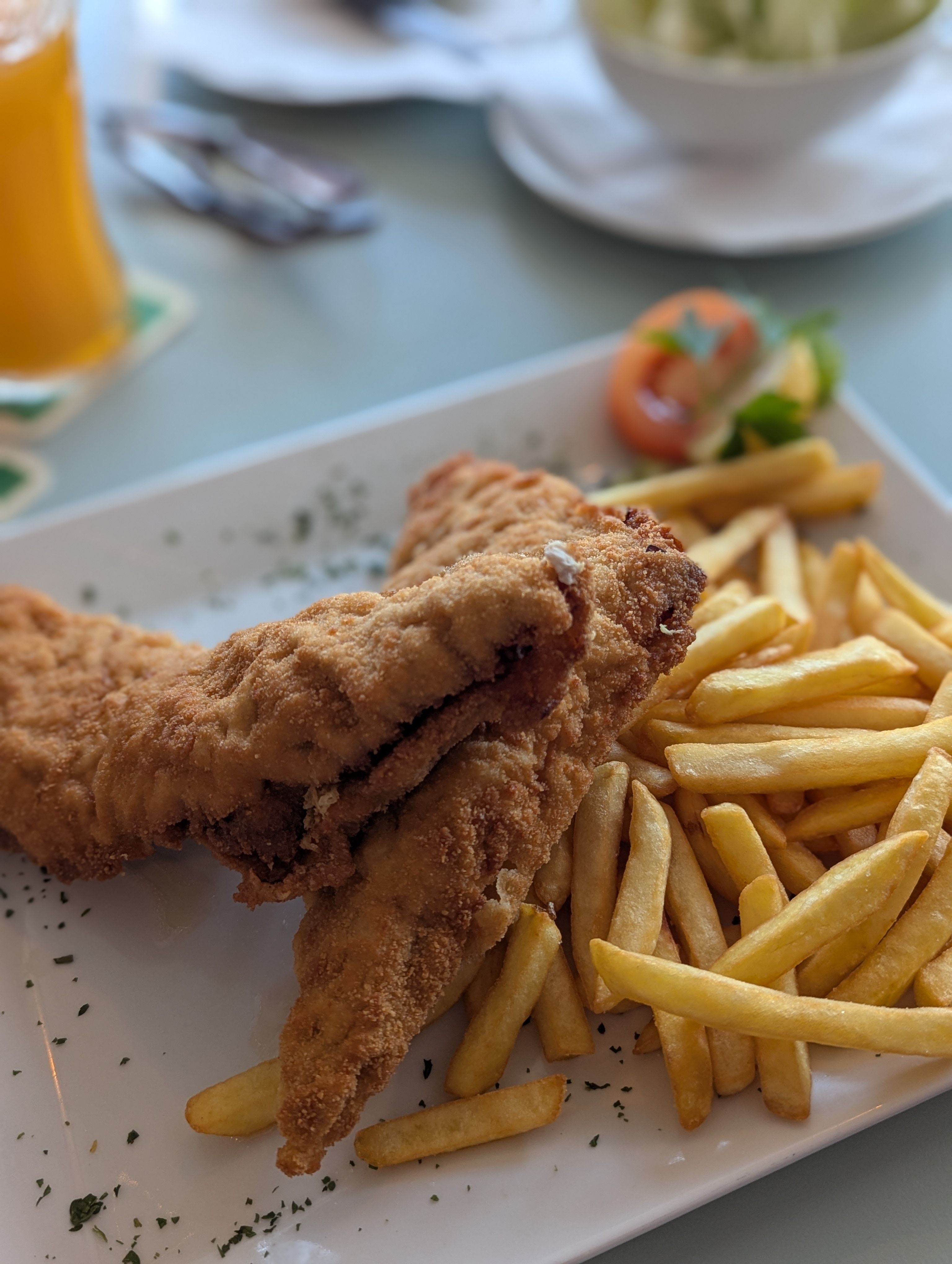 Schnitzel és sült krumpli fehér tányéron