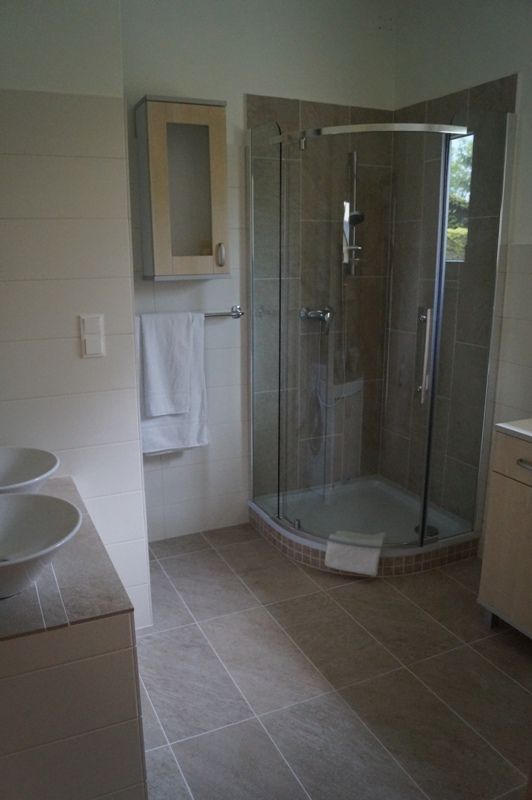 Modernes Badezimmer mit Dusche, Waschbecken und Handtuchhalter.