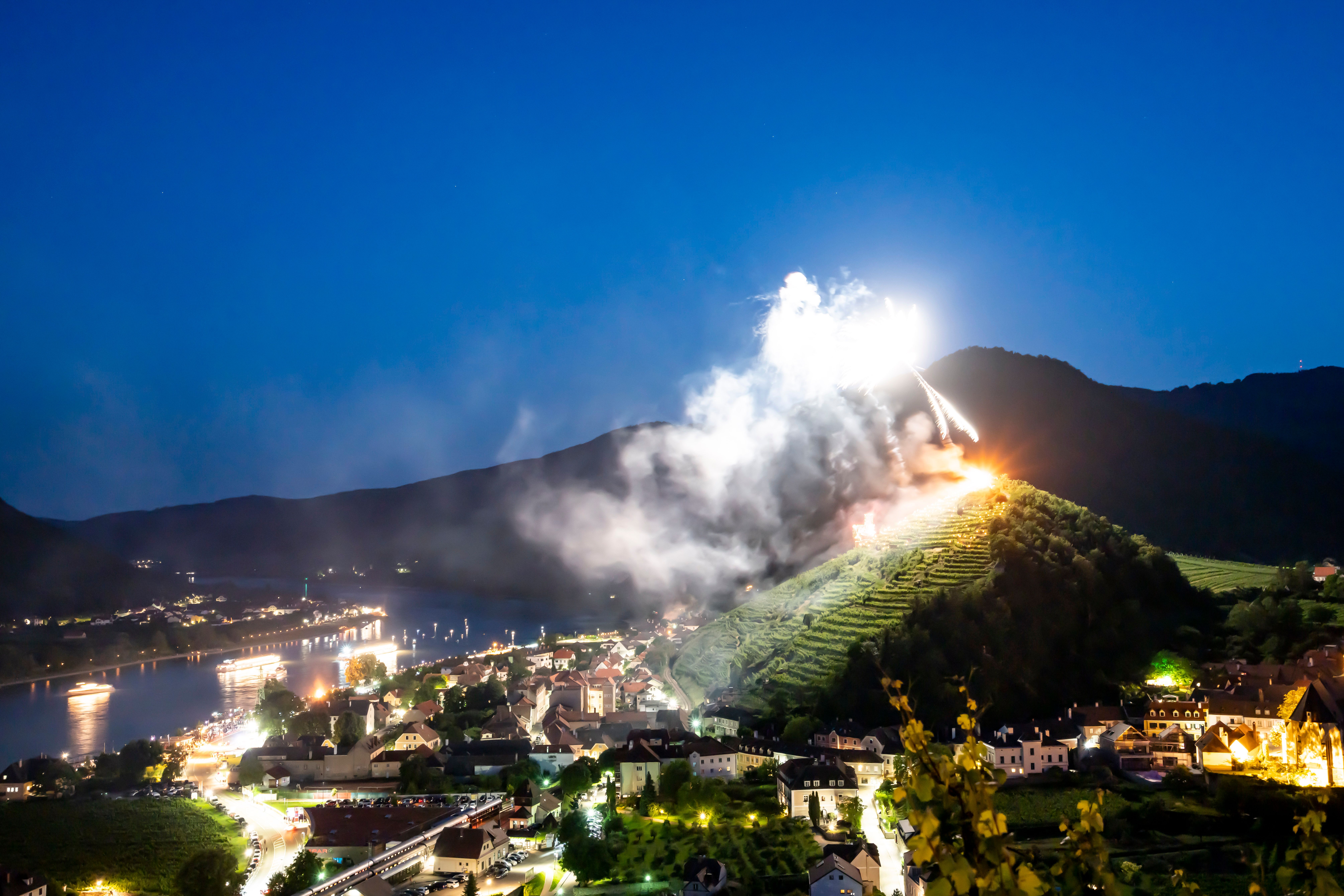 Sonnwendfeuern in Spitz mit beleuchteten Schiffen auf der Donau